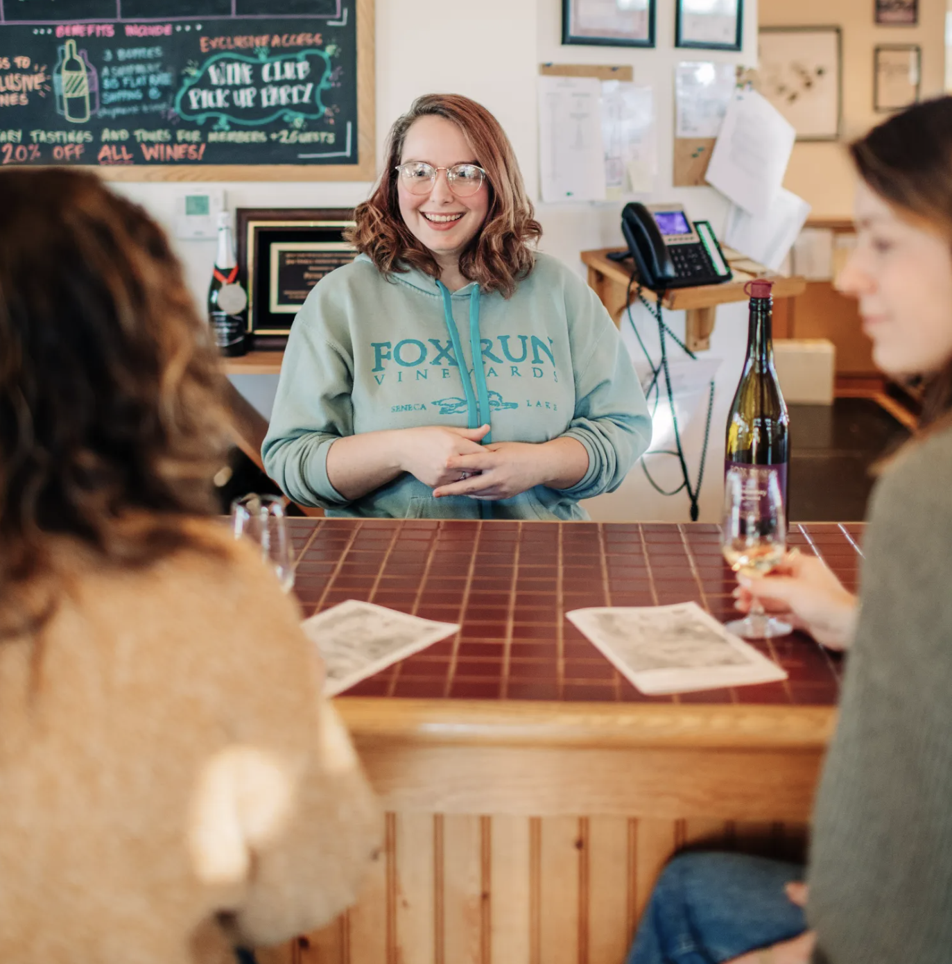 bartender greeting two guests at the tasting room bar