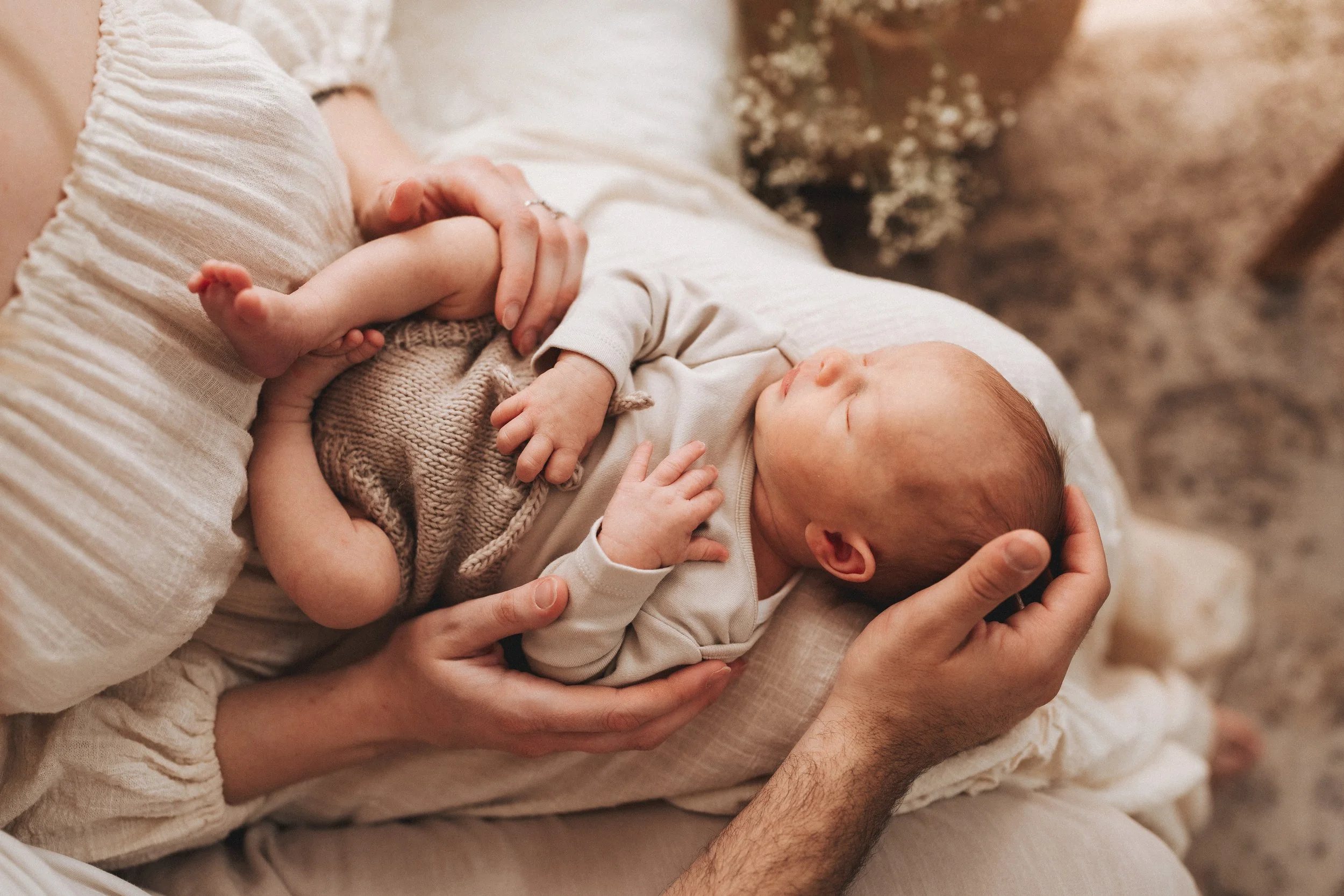 Servizio fotografico newborn a Prato, Firenze e Pistoia, neonato tra le braccia della mamma in studio, stile naturale e spontaneo.