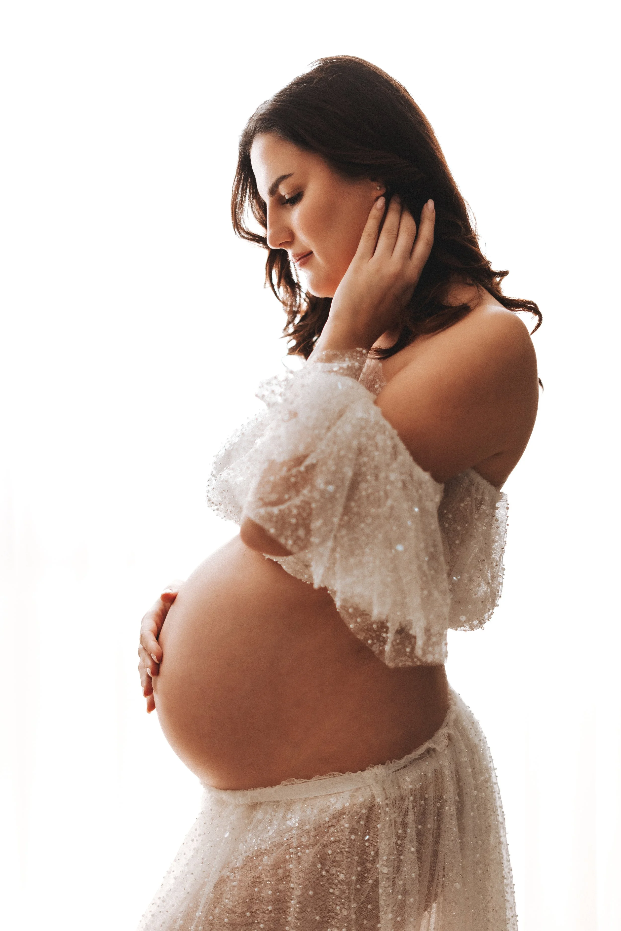 Futura mamma sorridente durante servizio fotografico gravidanza in studio a Prato.