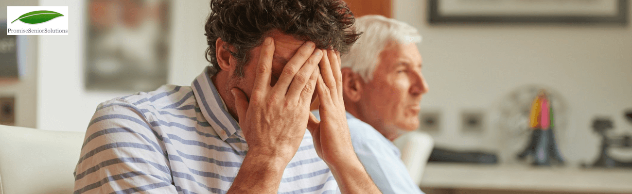 An older man with white hair sitting at a table with a thoughtful expression in the background, and a middle-aged man with curly hair holding his head in distress in the foreground.