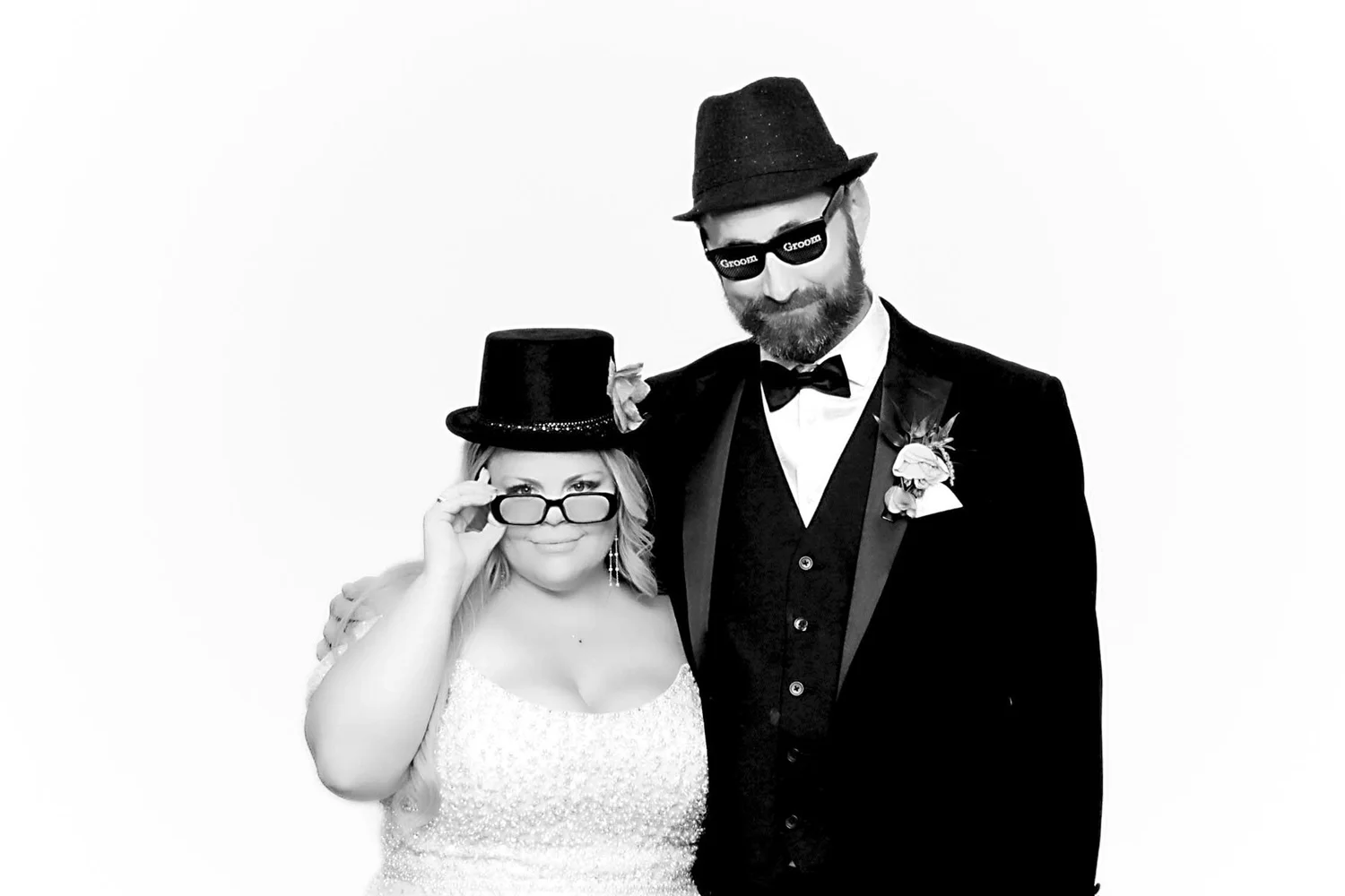 A playful black-and-white wedding portrait of a newlywed couple