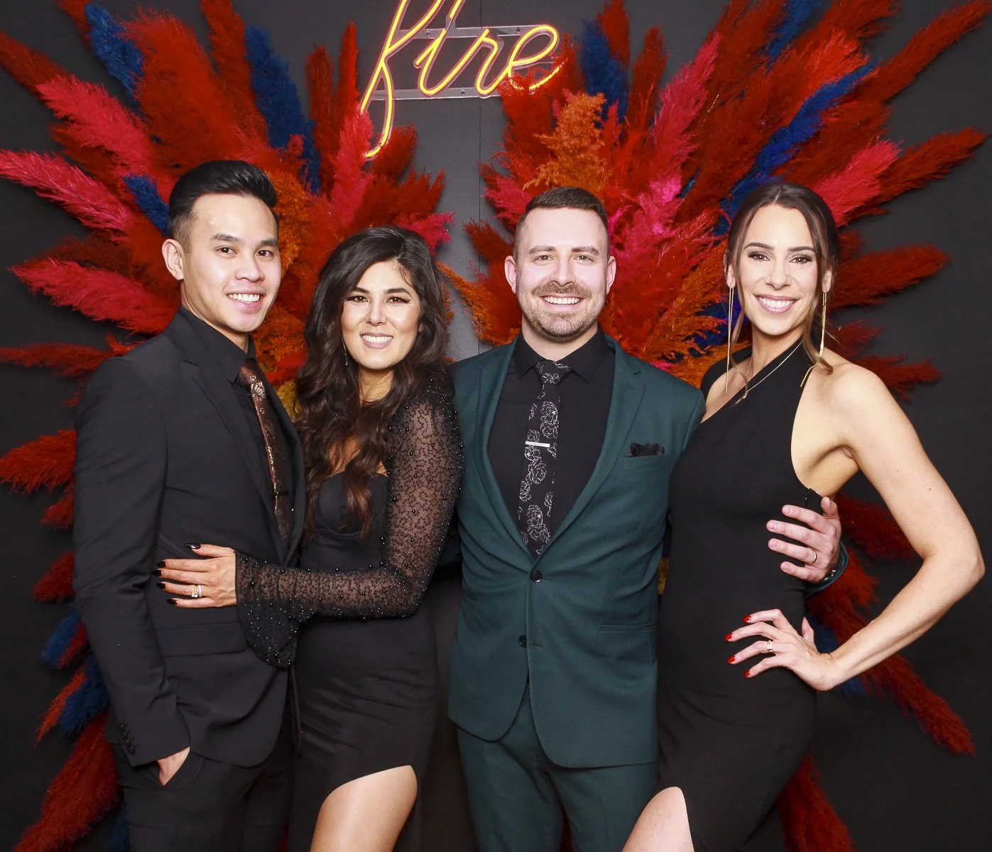 Four event guests sharing a studio portrait in a colorful floral setting