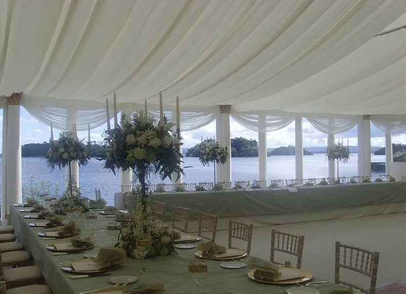 Tall arrangements of white and cream flowers add height and freshness without blocking the stunning scenery.