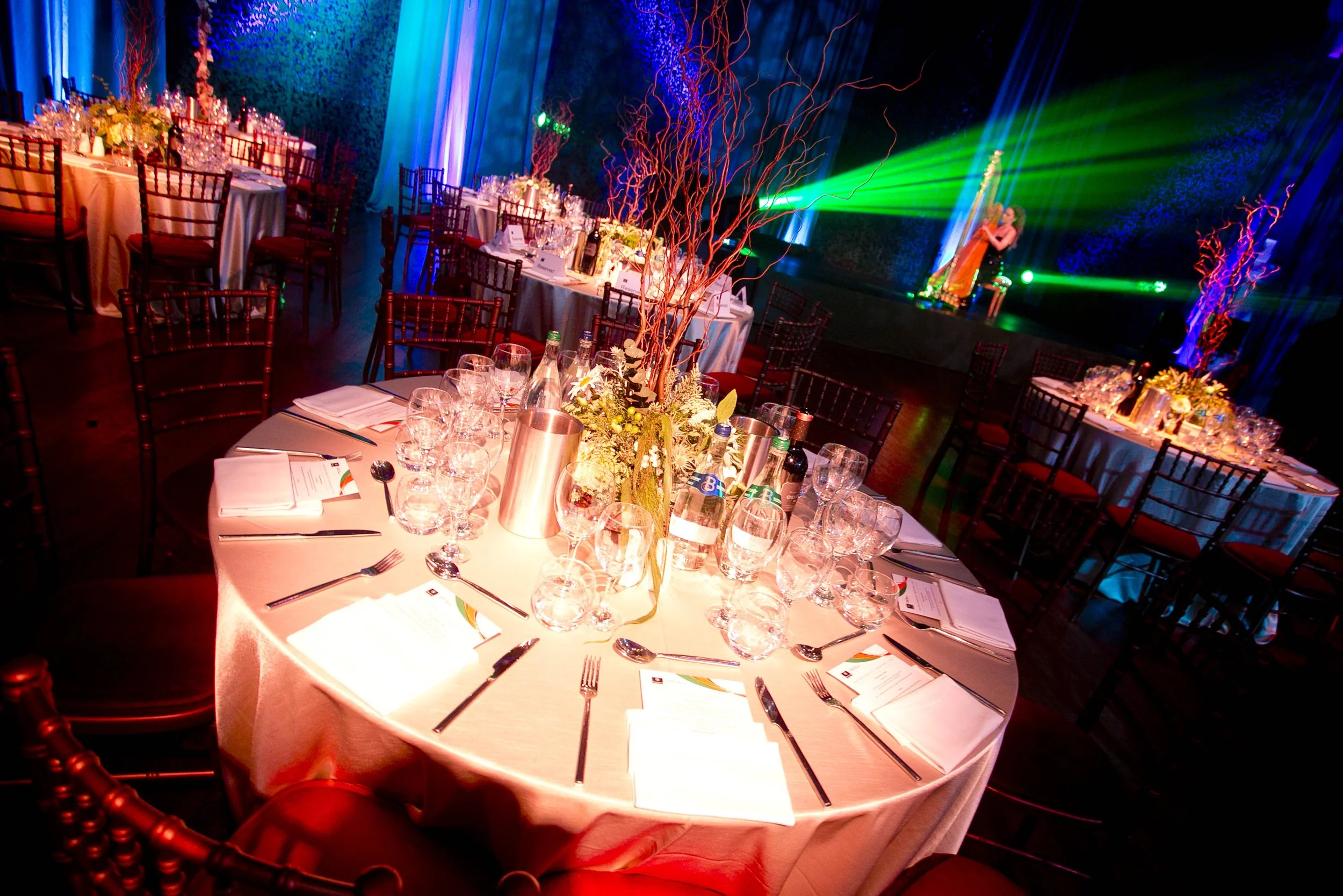 The combination of dynamic lighting, bold colour contrasts, and lush floral accents creates an energetic, celebratory atmosphere