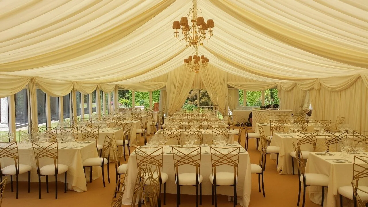 Ivory Draped marquee roof with chandeliers and curved bar