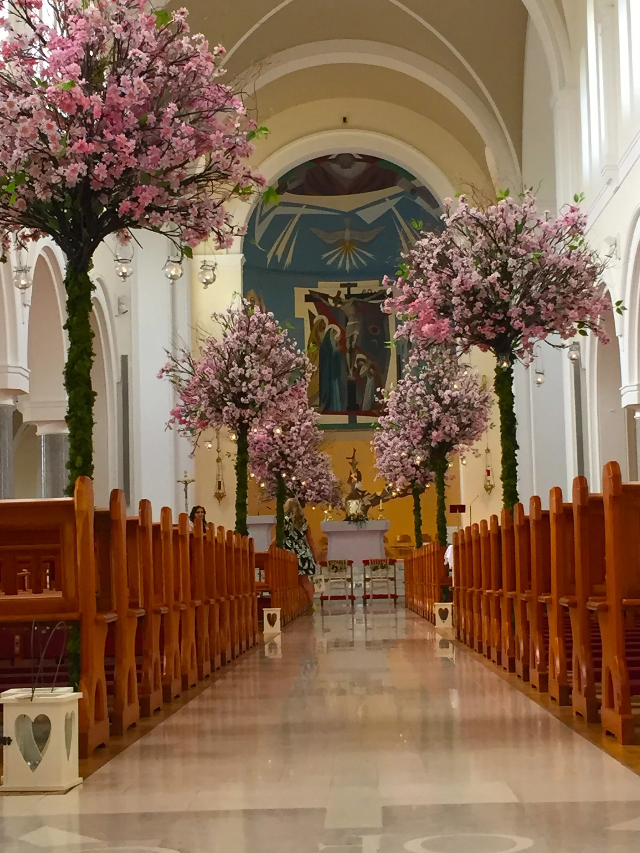 a church interior transformed into a romantic, blossom‑filled aisle.