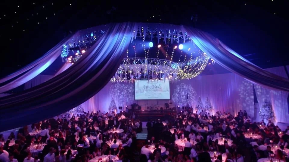 This image captures a dramatic winter‑wonderland event setting bathed in deep blue light.