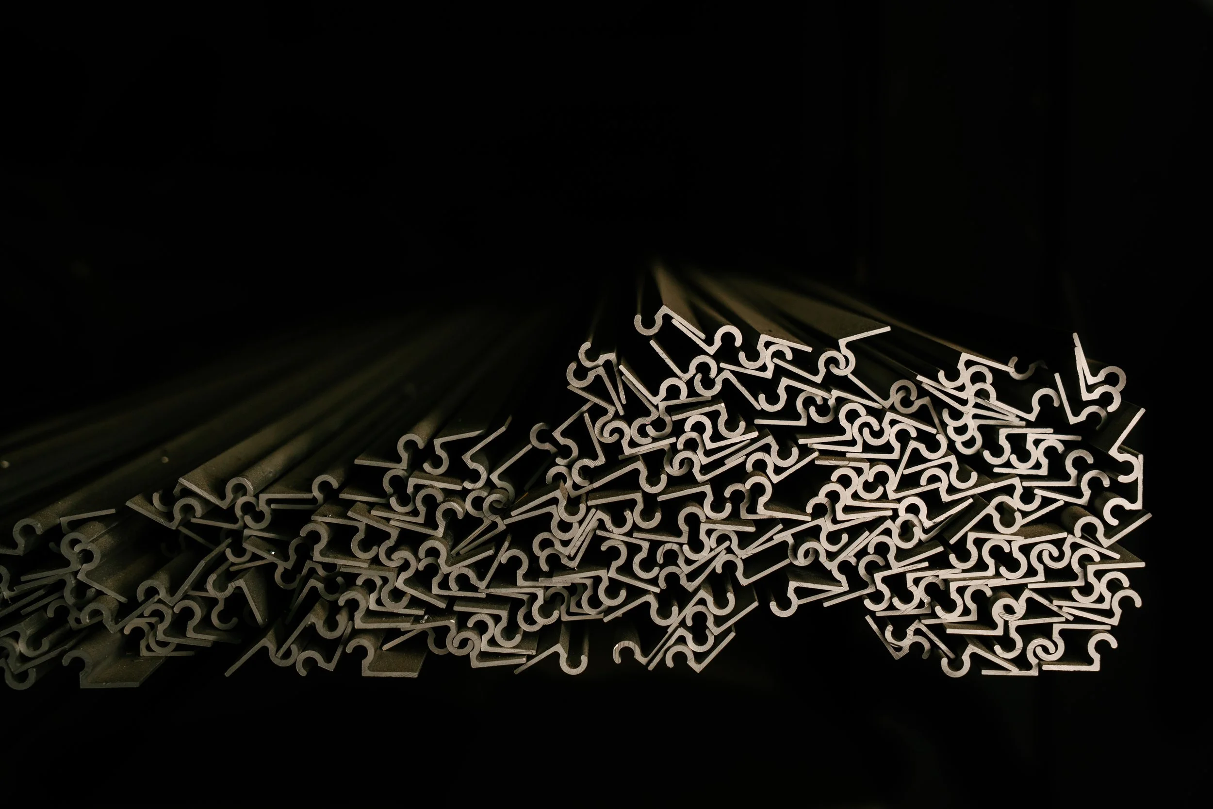 A pile of metal hooks arranged in a dense cluster.