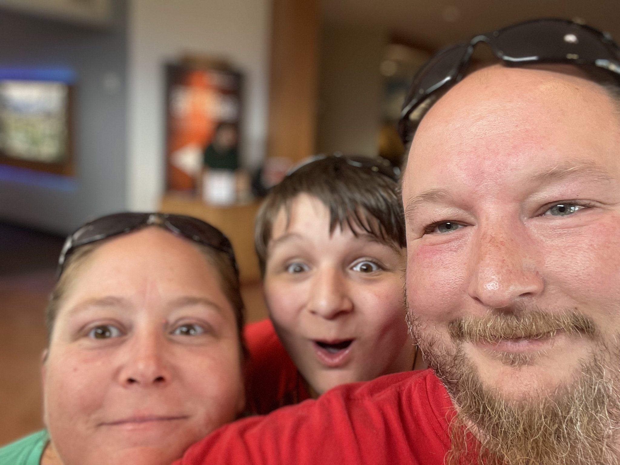 Three people taking a close-up selfie together inside a room.