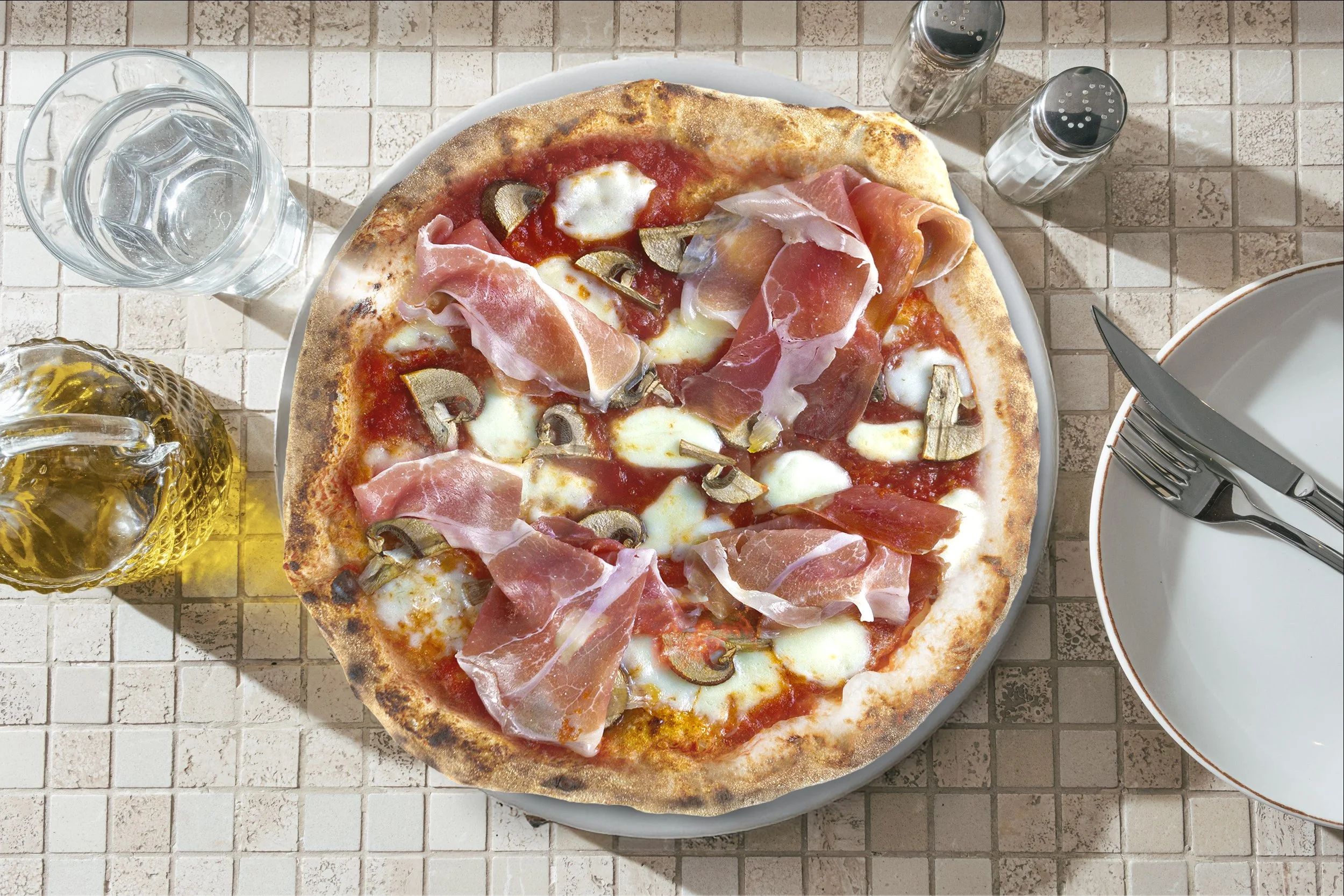 Pizza Napoletana autêntica da Ánima Pizzaria com borda aerada e chamuscada (cornicione), molho de tomate San Marzano D.O.P. e COGUMELOS PORTOBELLO fresco sobre prato de cerâmica."