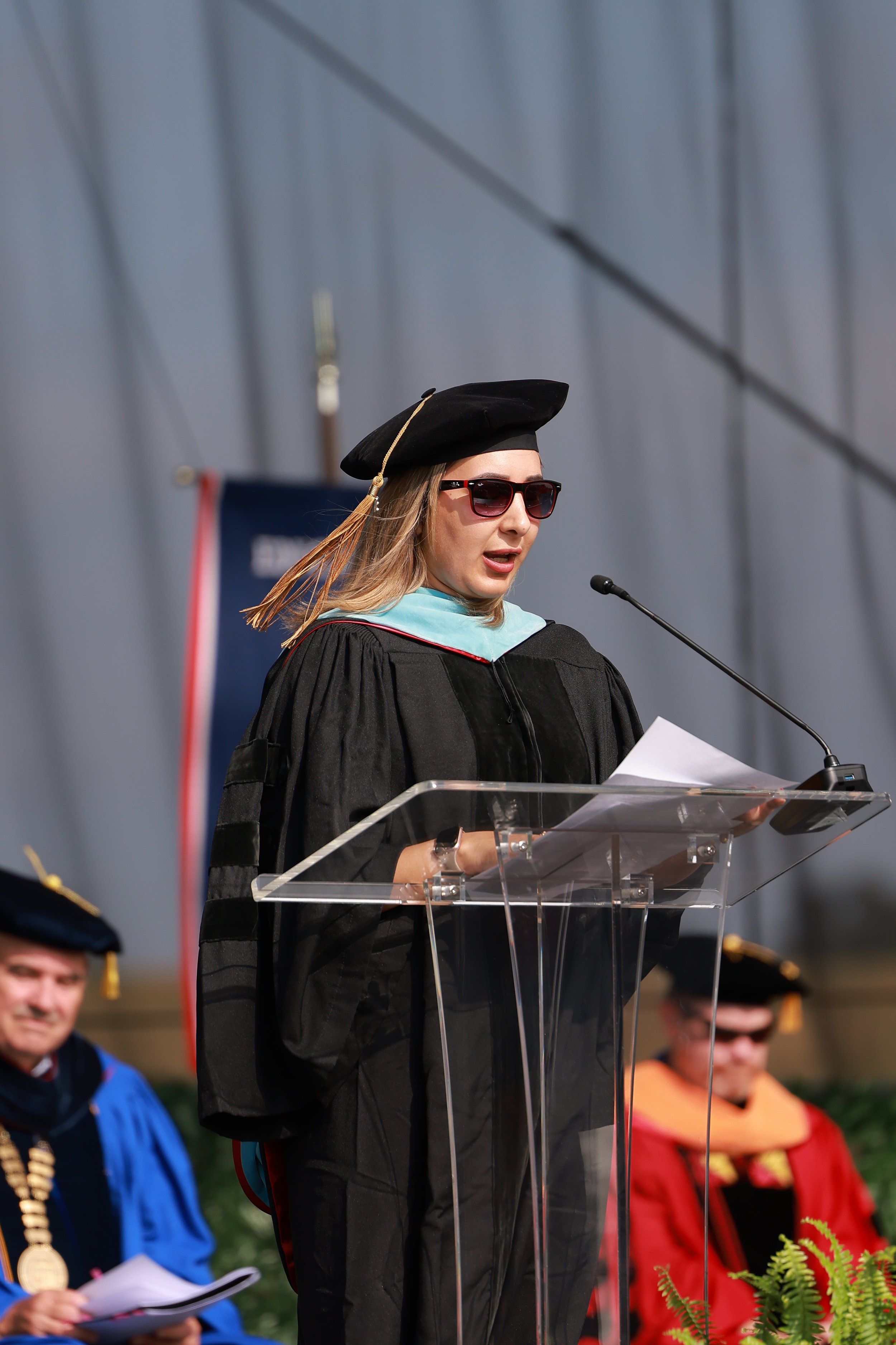 woman standing and giving speech in front of the public