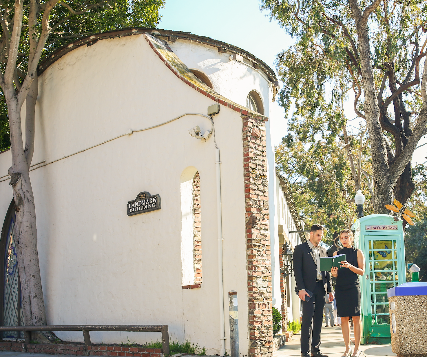 A man and a woman standing beside a building