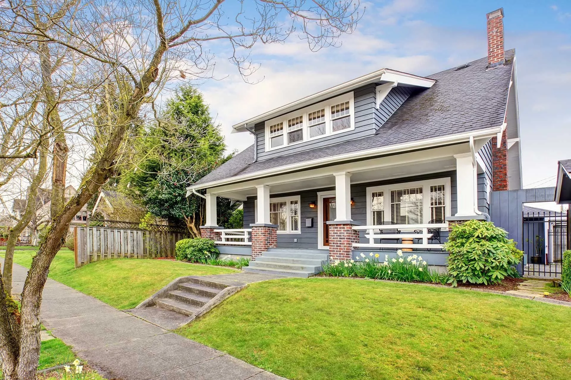 Front of residential home with plantings and green lawn