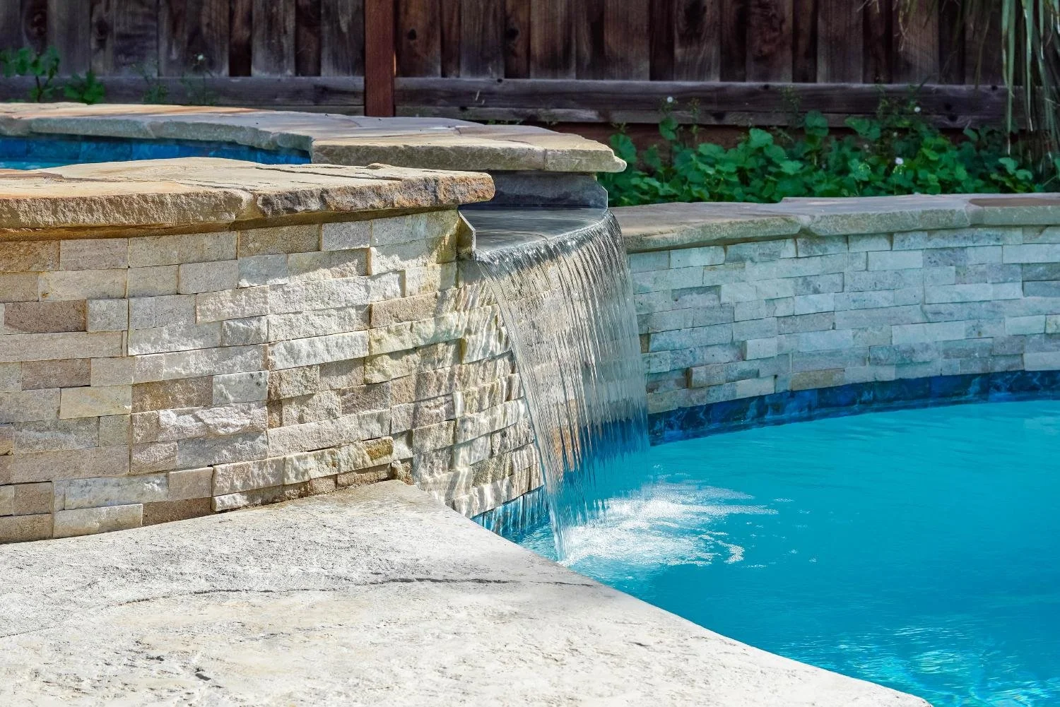 Modern sheer descent pool waterfall by Luck Lagoons