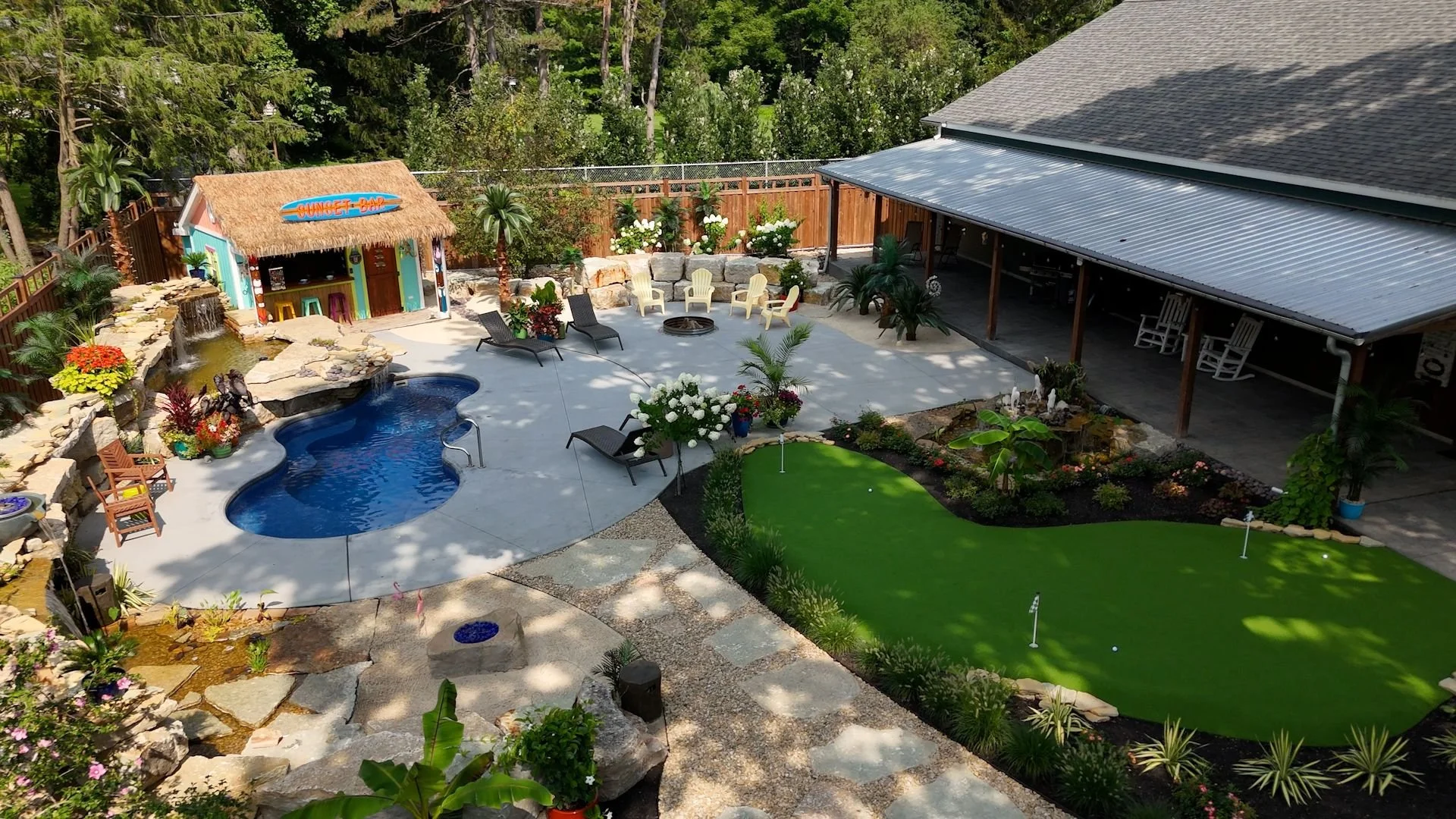 Freeform pool with sun shelf and boulder waterfall by Luck Lagoons