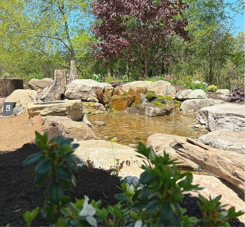 Natural rock water feature and pond designed by Luck Lagoons with custom landscape design and cascading waterfall