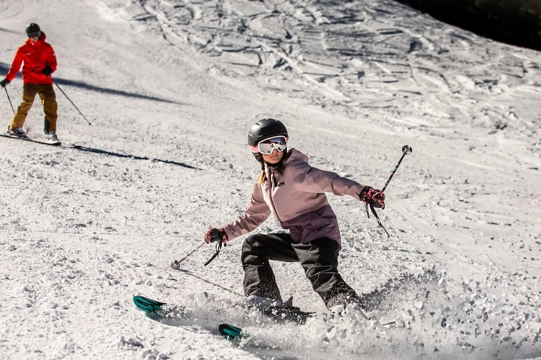Young girl in pink jacket skiing in front of a commercial photographer in Bend Oregon's Mt. Bachelor. Steve Heinrichs is one of the best commercial photographers in Bend.
