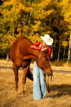 Horse and young woman in a field for Western style senior photos in Bend Oregon