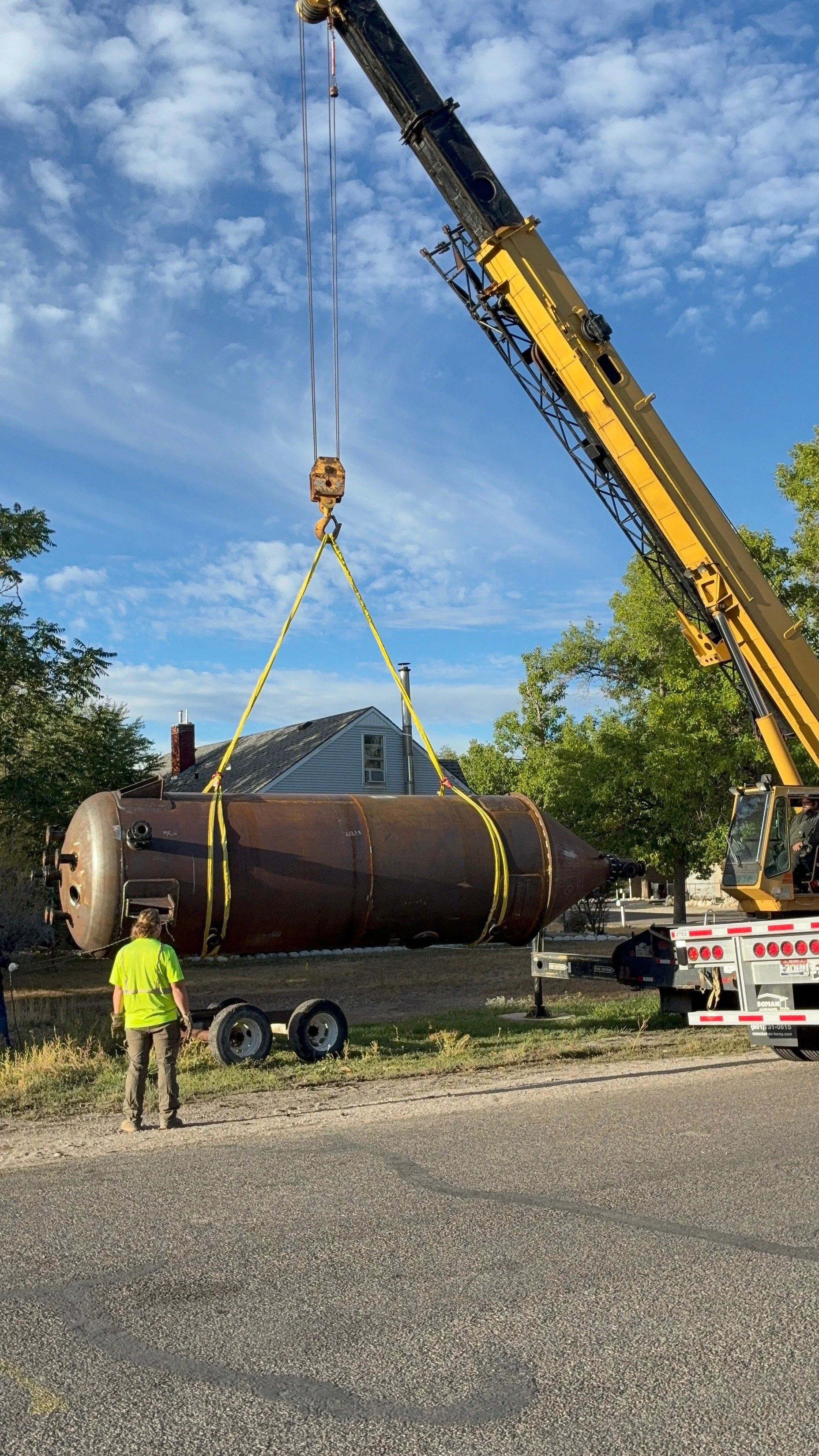 A heavy-duty industrial AMSE pressure vessel being lifted by a crane for transport and delivery by Peak Welding and Fabrication.