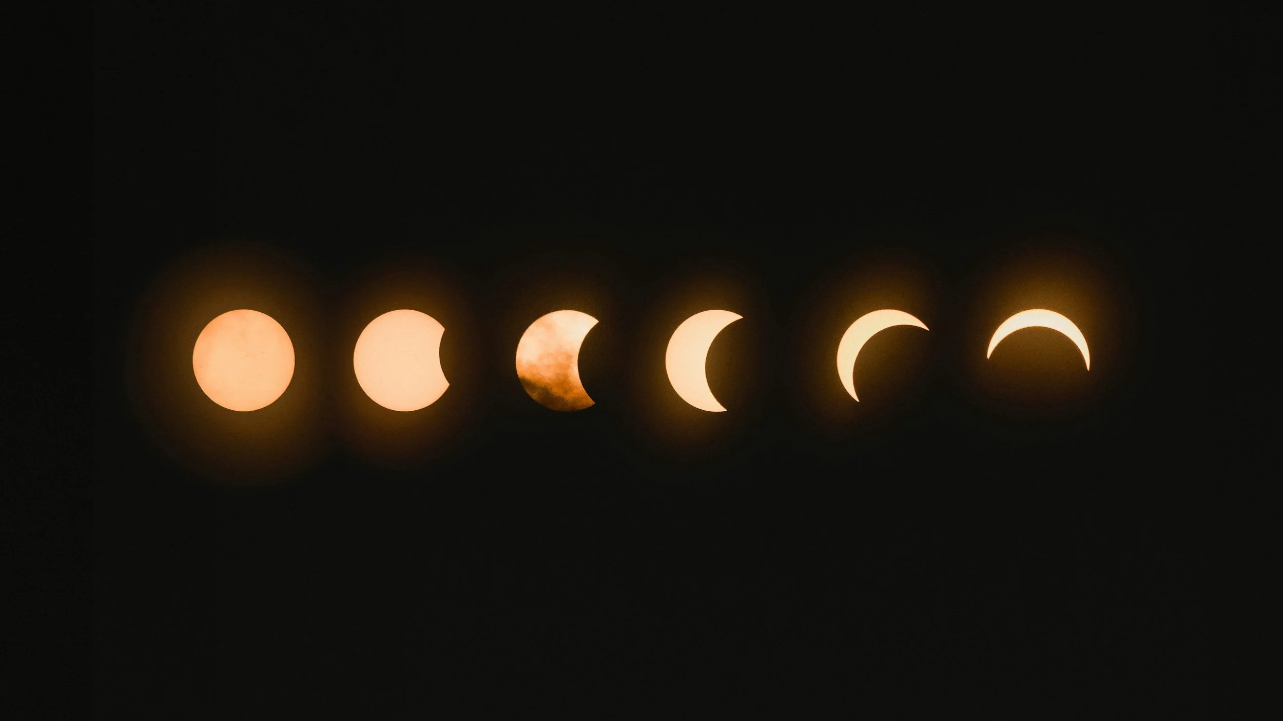 Sequence of six images showing different phases of a solar eclipse against a black sky.