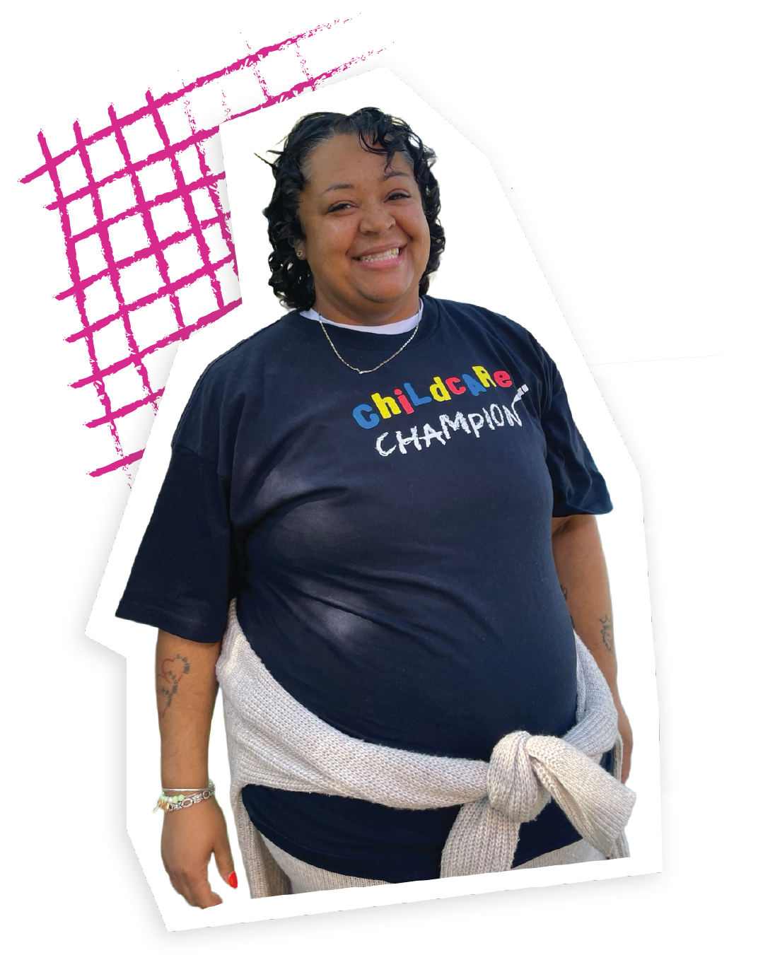 A female early educator smiles at the camera wearing a black "Childcare Champion" t-shirt.