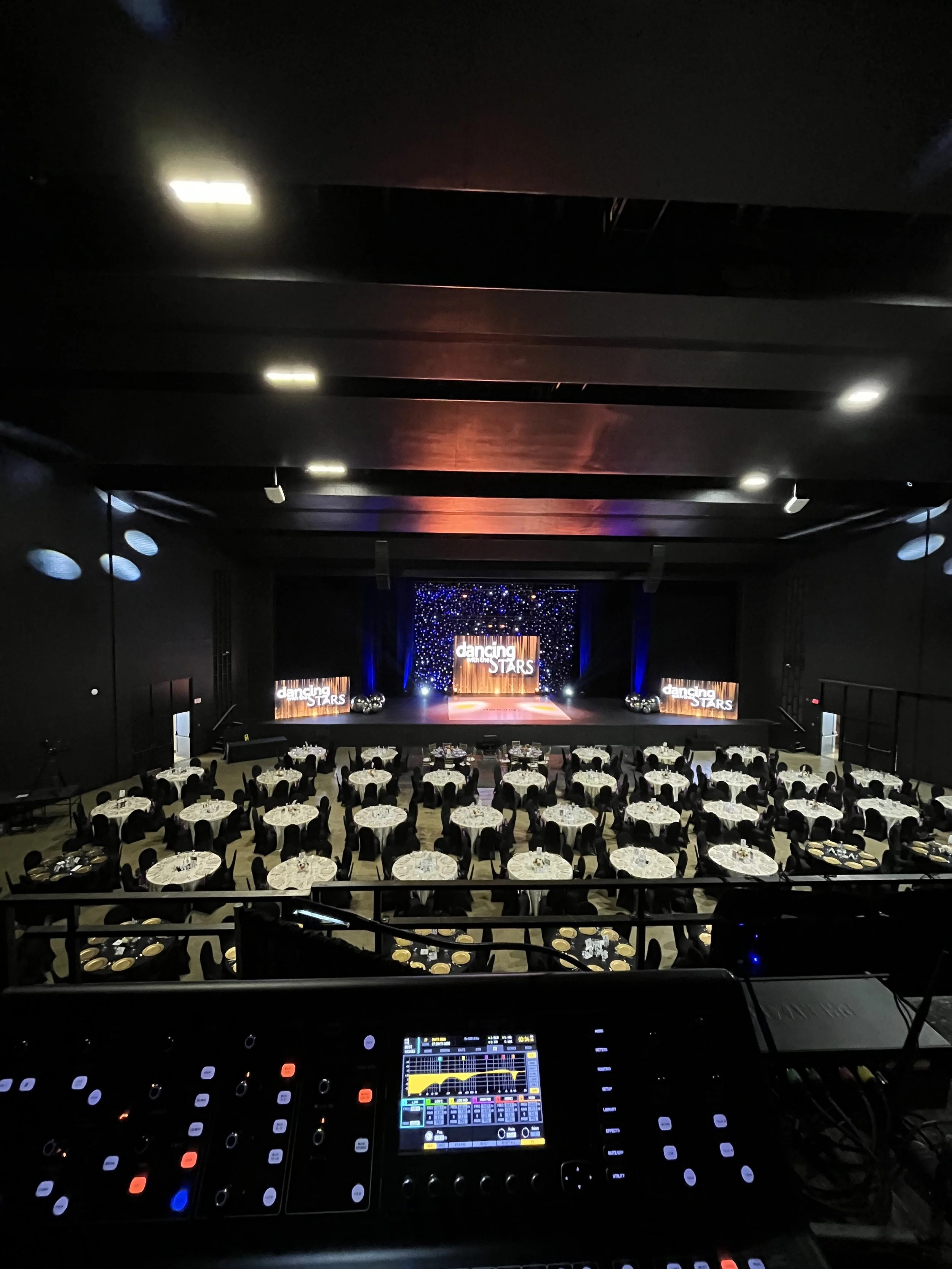 Big events room with tables and people listening to speaker.