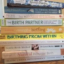 Stack of books about childbirth, pregnancy, and childbirth methods.
