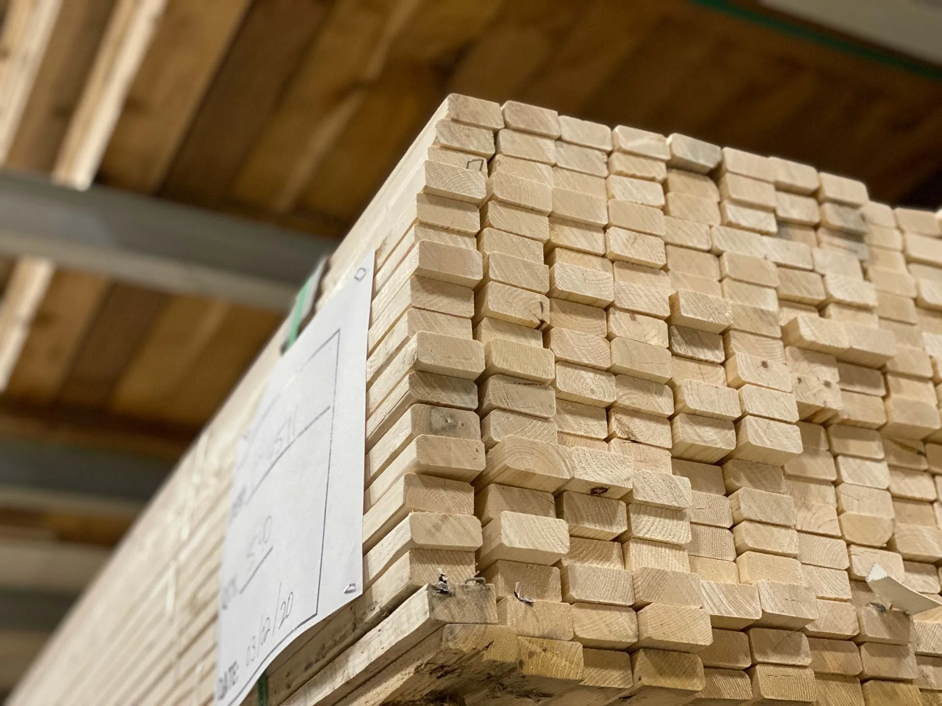 A stack of rectangular wooden blocks stored in a warehouse.