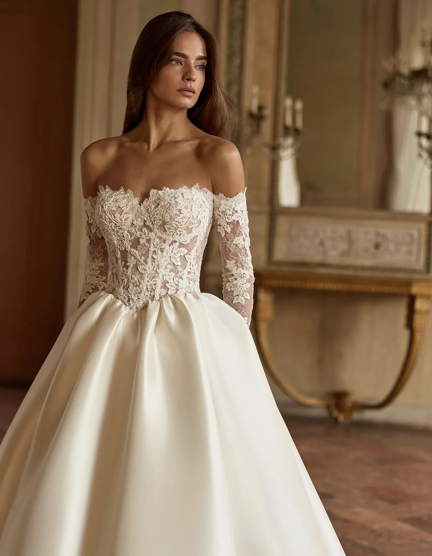 A woman in a wedding dress standing in an elegant room with ornate furniture and decor.