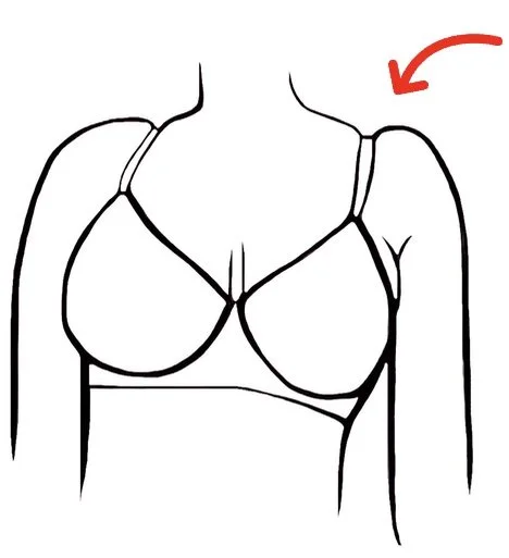 Line drawing of a woman's upper body in a bra with an arrow pointing to her shoulder.