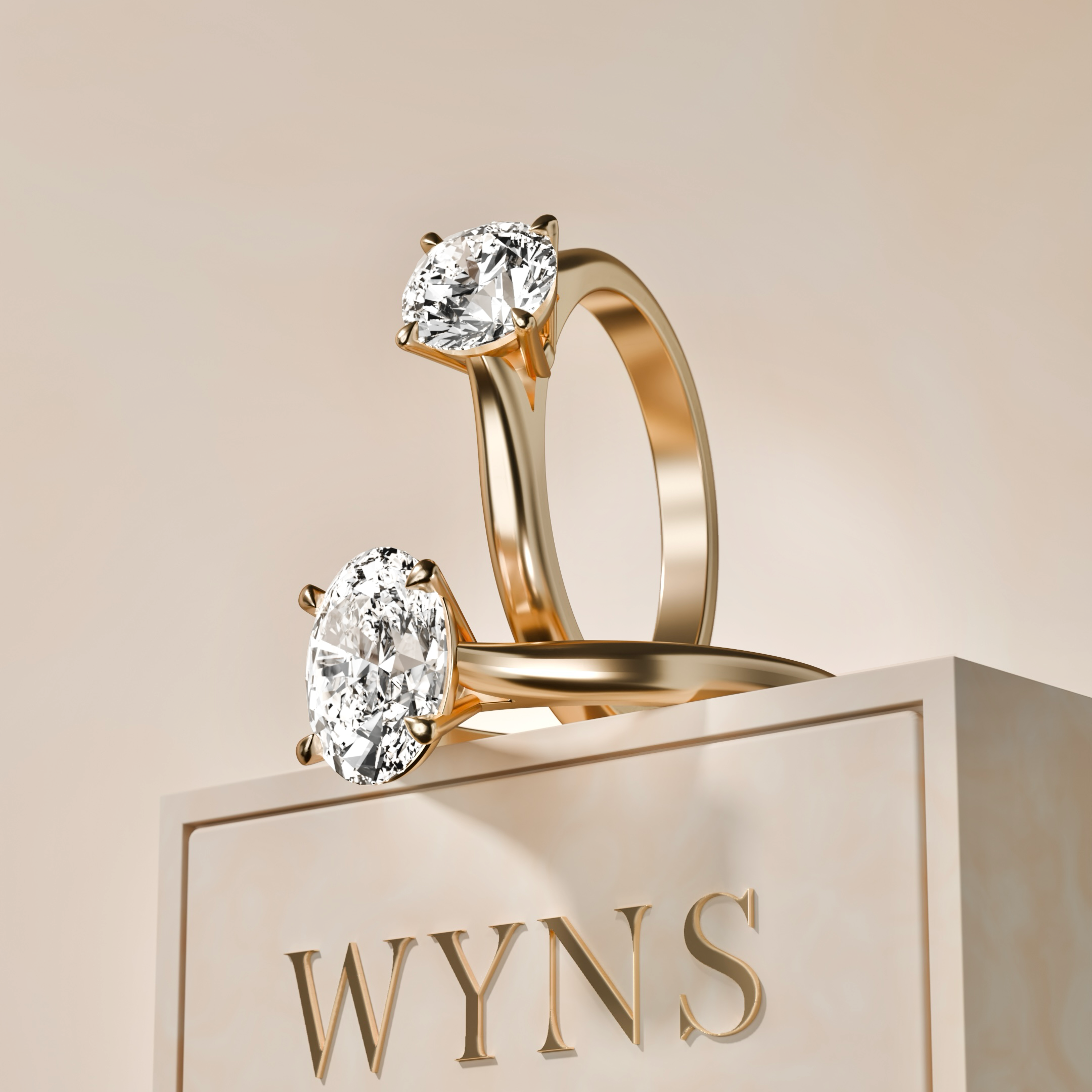Two gold rings with large diamonds displayed on a platform with the brand name WYN'S.