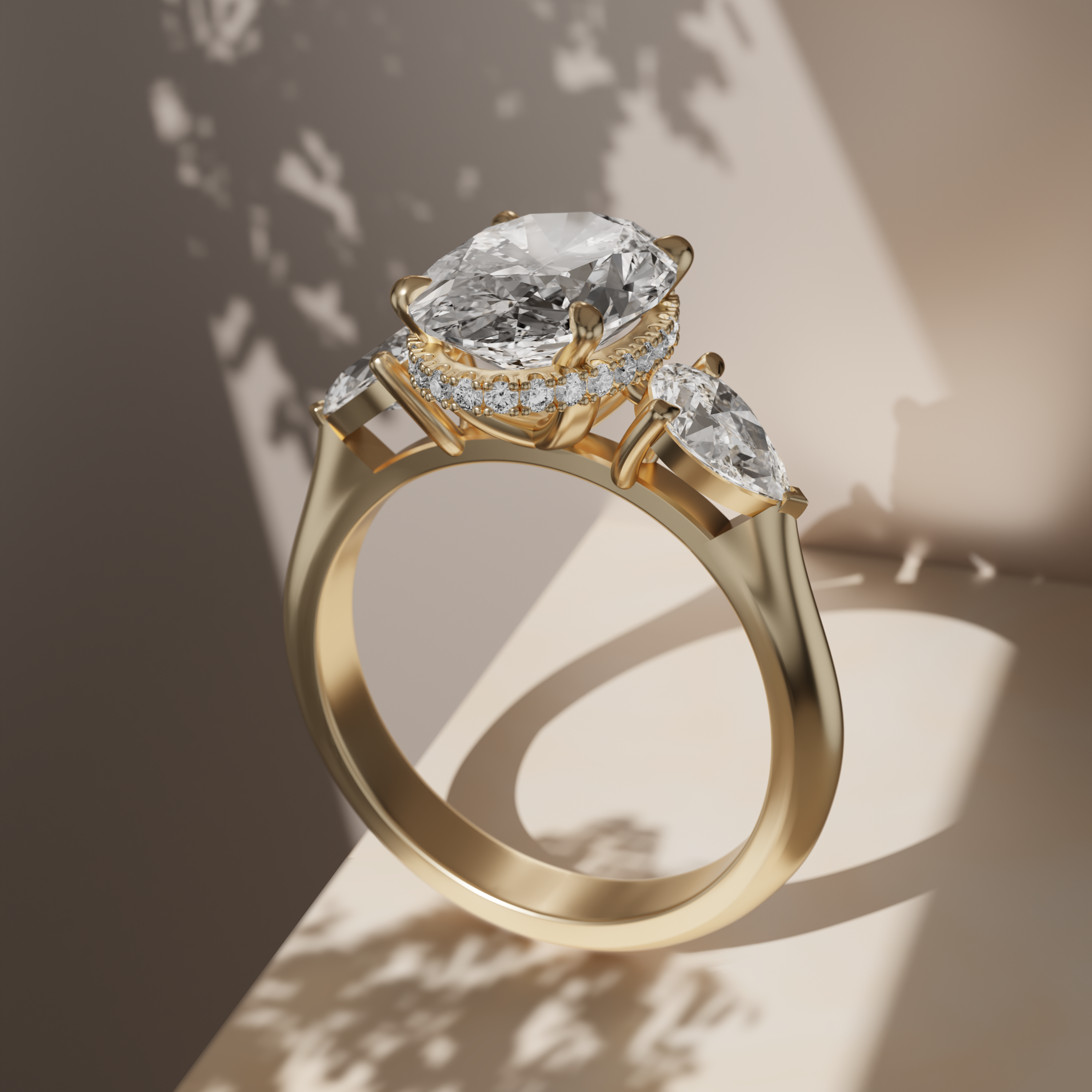 A yellow gold 18K ring with a large oval diamond and two pear-shaped diamonds, with a hidden halo set against a beige background with dramatic shadows.
