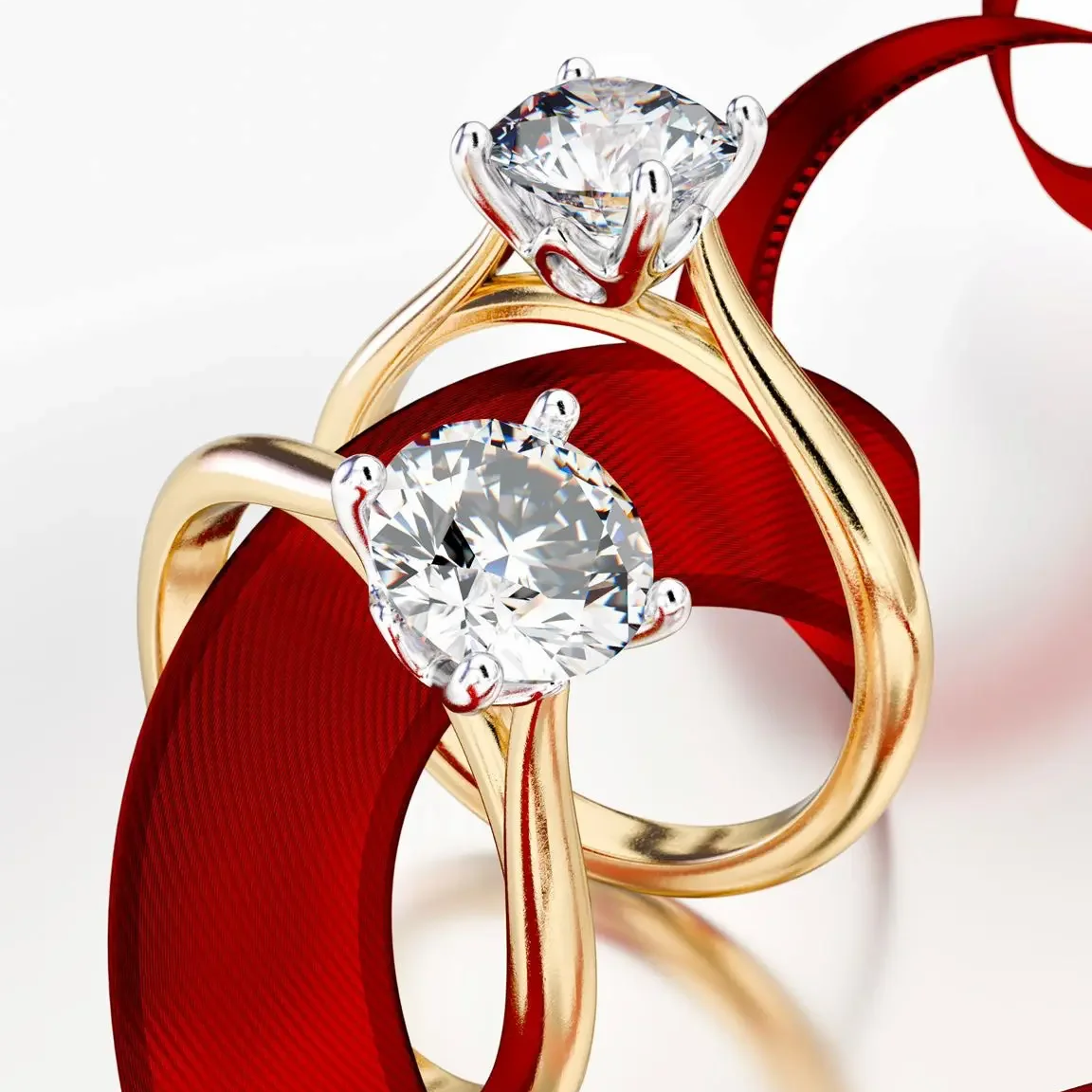 Two gold rings with large, sparkling diamonds, intertwined with a red ribbon.