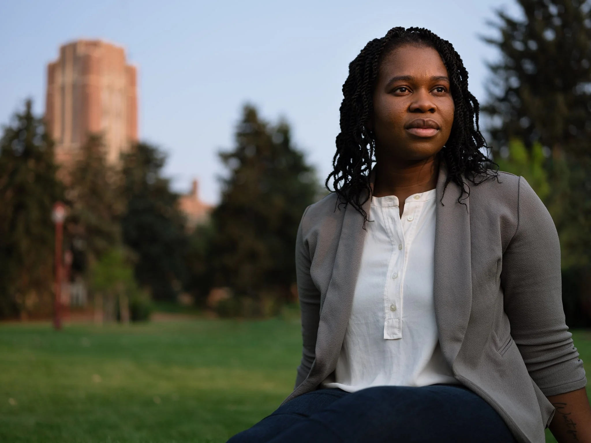 Nathalie Dieujuste, one of the few black students in the University of Denver psychology graduate program, sitting in the campus grass.