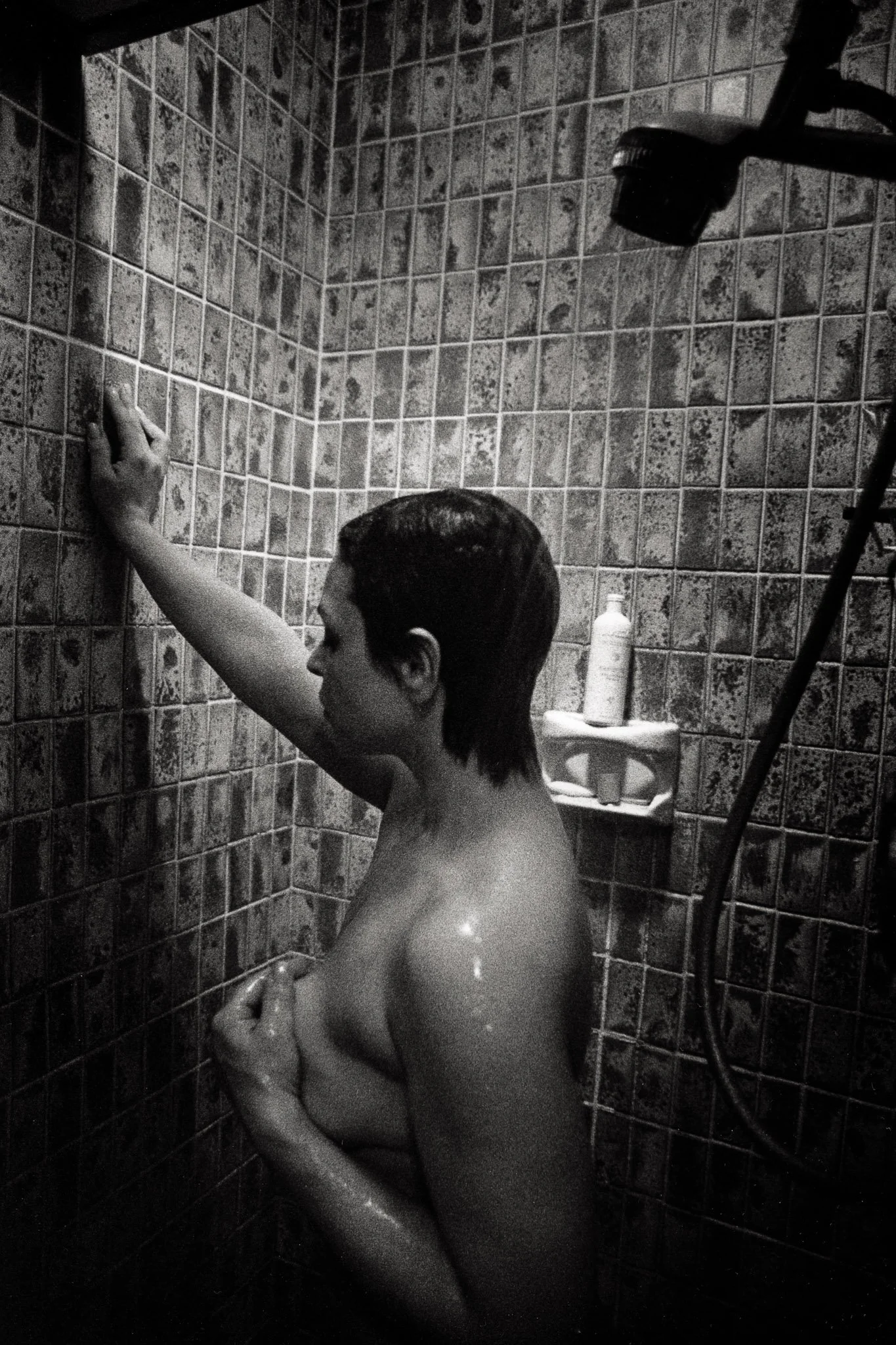 A woman in a dark shower at 4:30 a.m. clutches her breast for the last time on the morning of her  mastectomy.