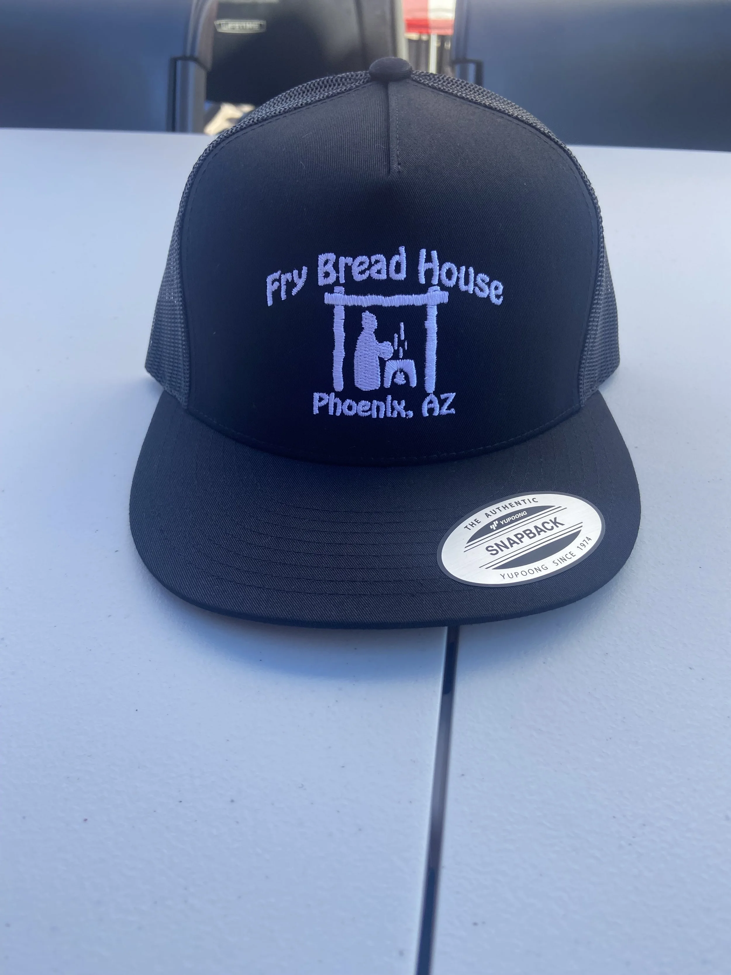 Black trucker hat with embroidery of a pantry and the text 'Fry Bread House, Phoenix, AZ' on the front