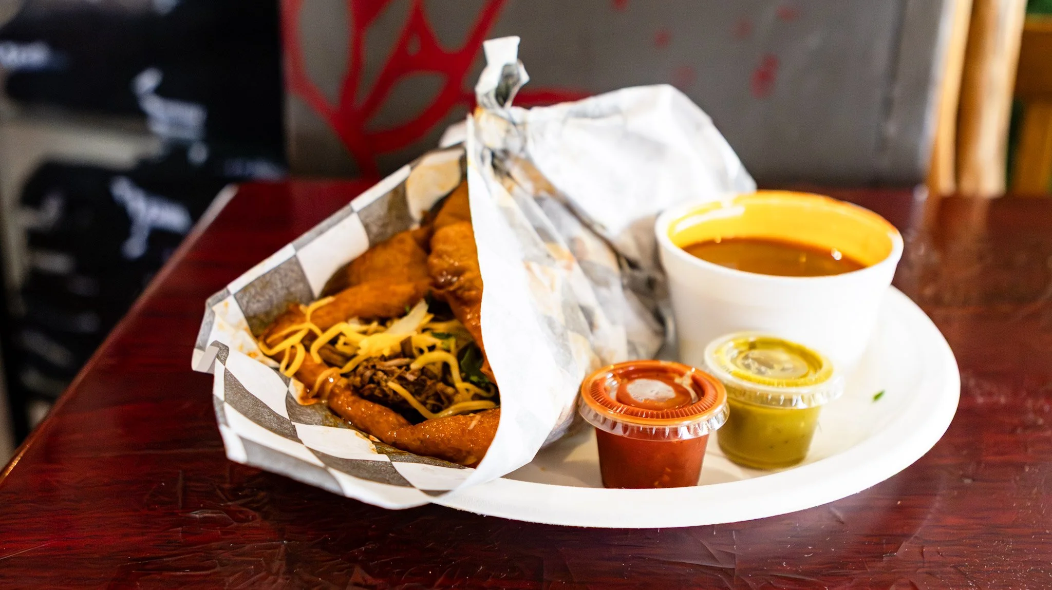 Mexican meal with tacos, hot sauce, and drink on a white plate