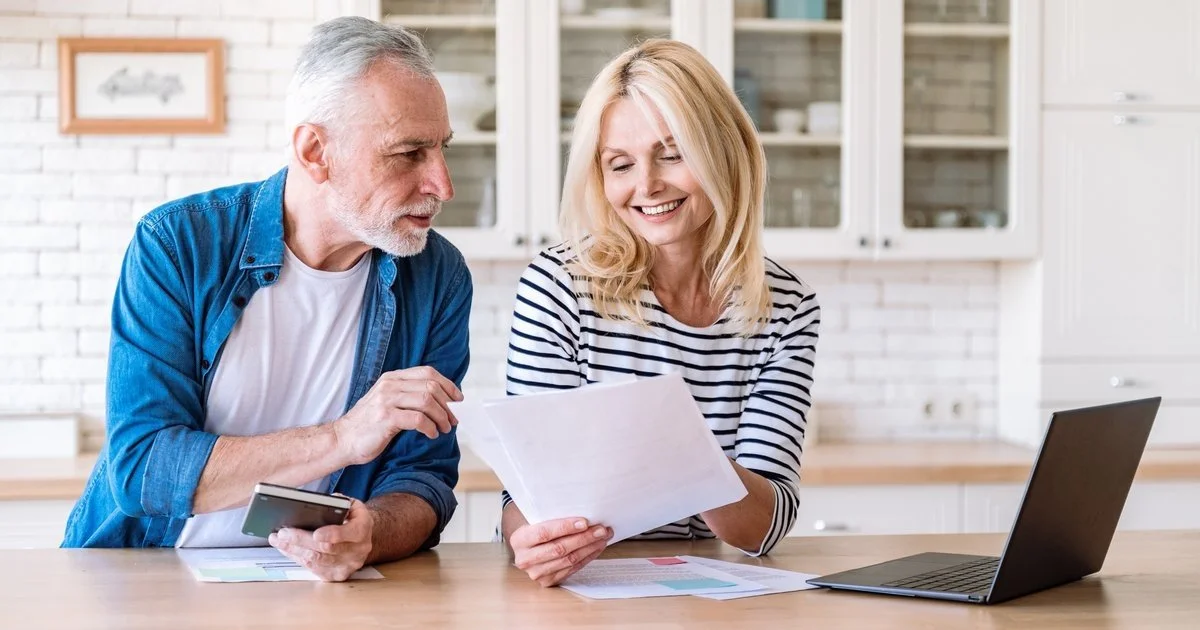 Veteran business owner and spouse reviewing family financial plan at kitchen table