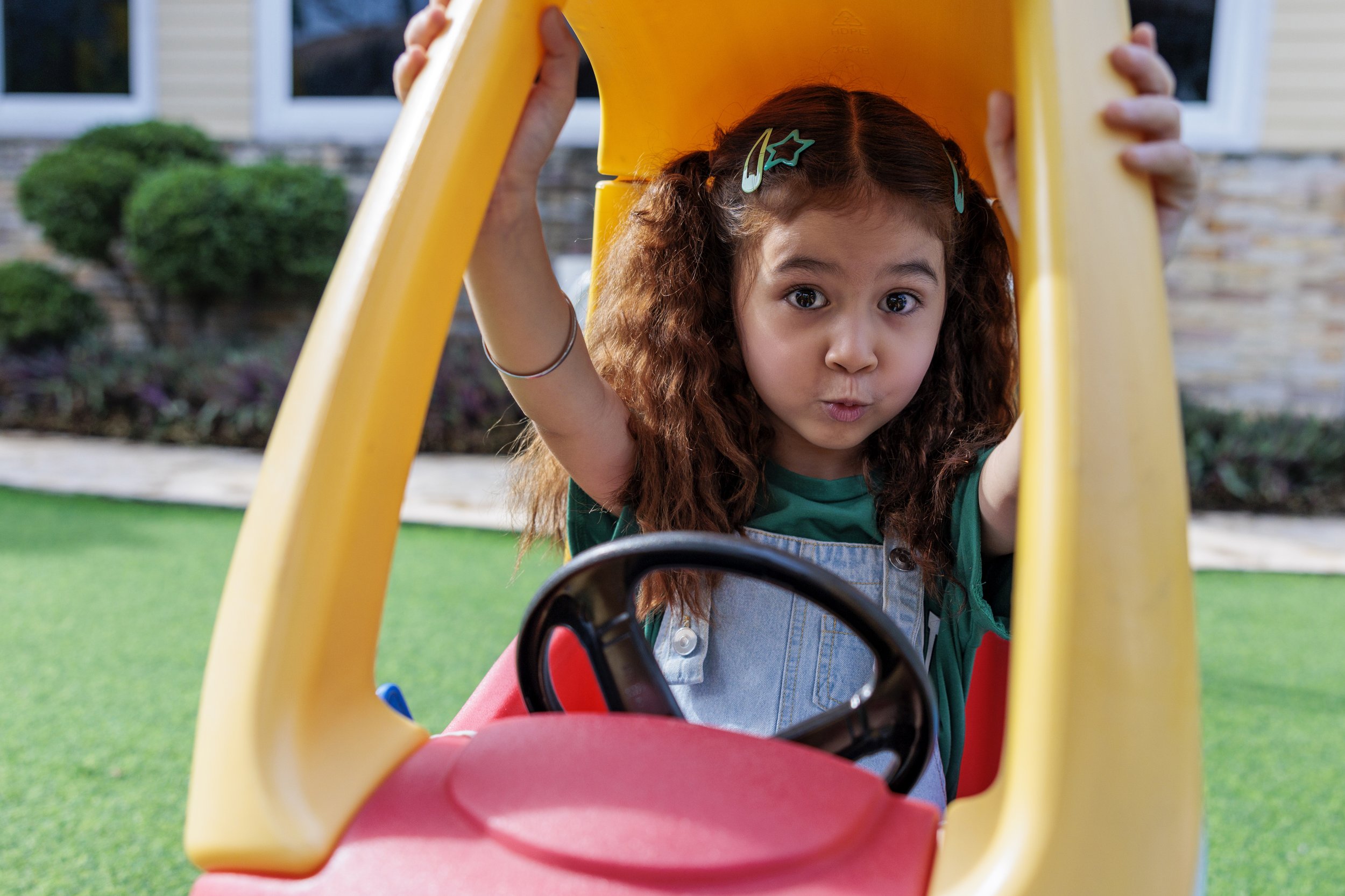Young child playing in a toy car