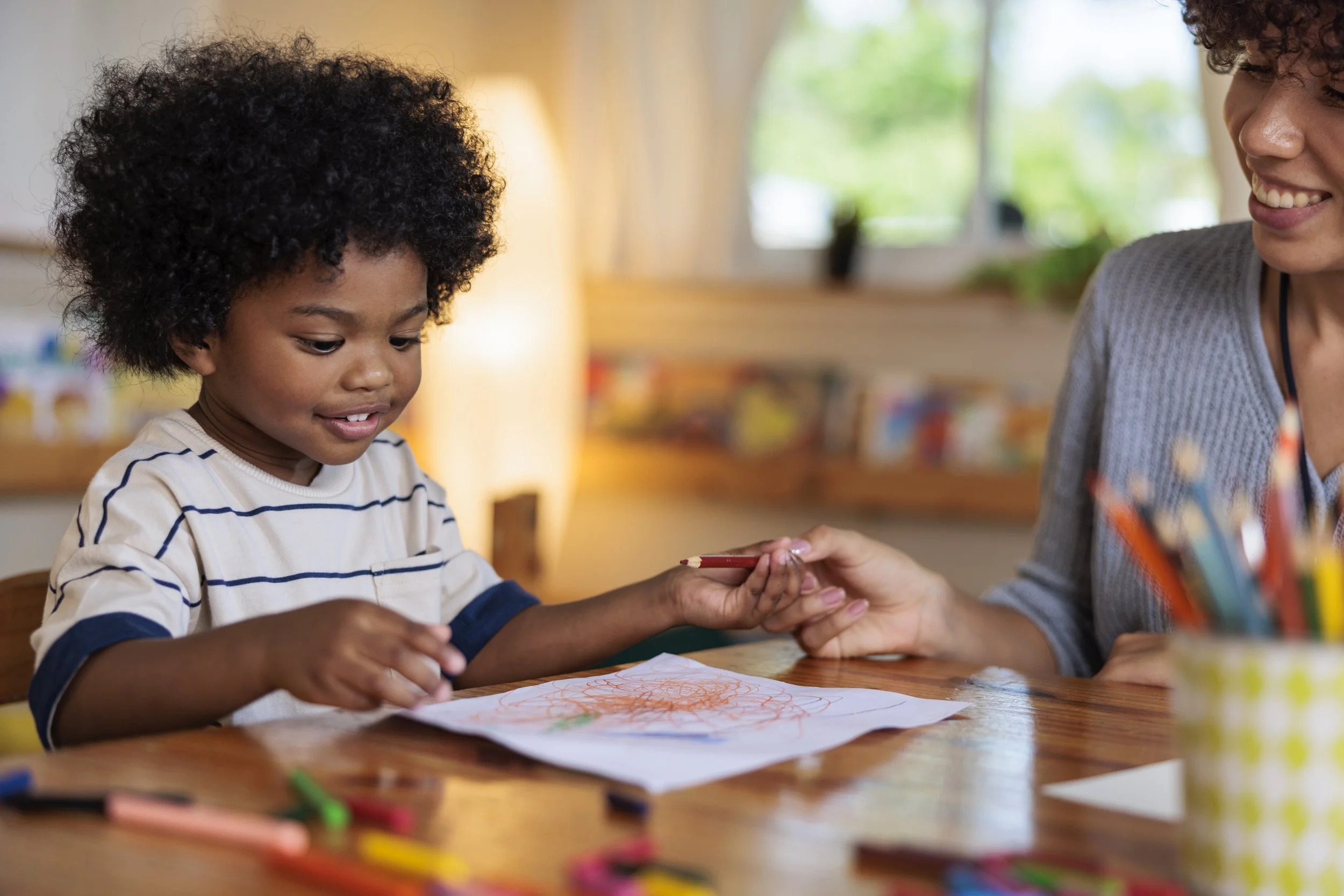 A young kid drawing on a piece of paper