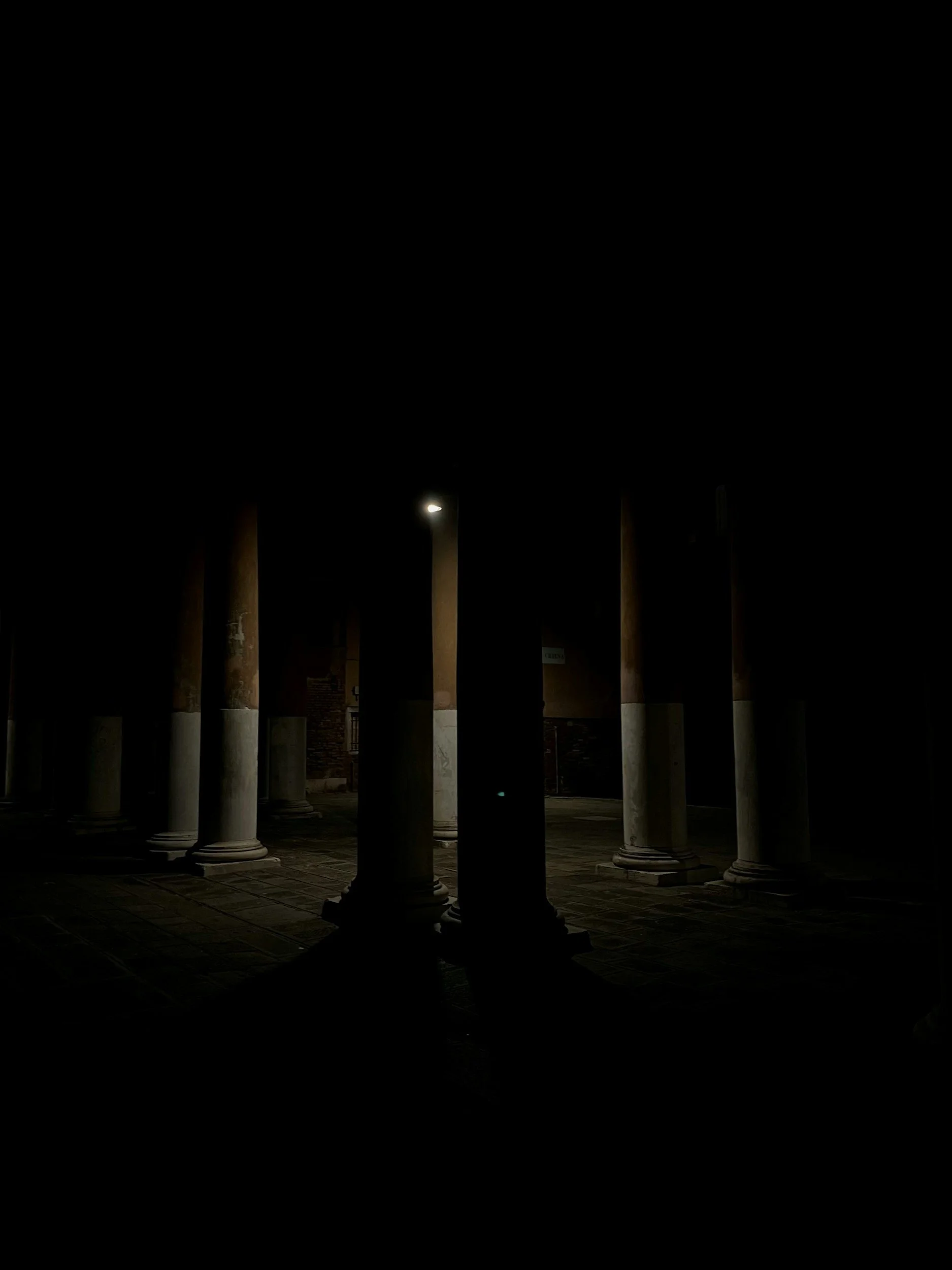 Night scene of several lit columns or pillars with a dark sky above.