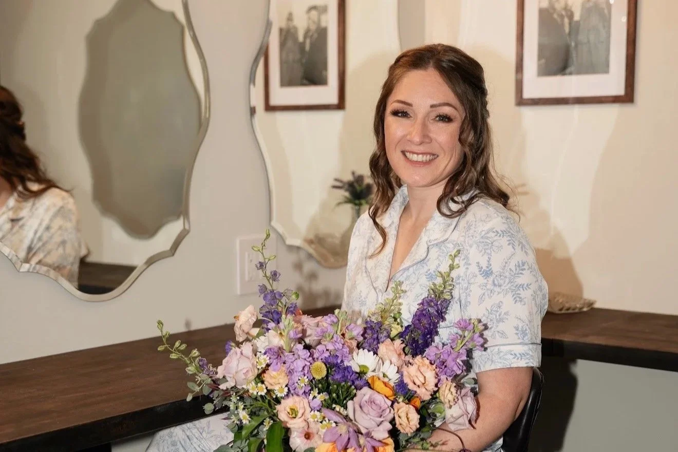 Bride posing pre-wedding in her get ready room in front of the mirror. Professional makeup by Ali Bell of Bell Sol Beauty & Esthetics in Salem, OR.