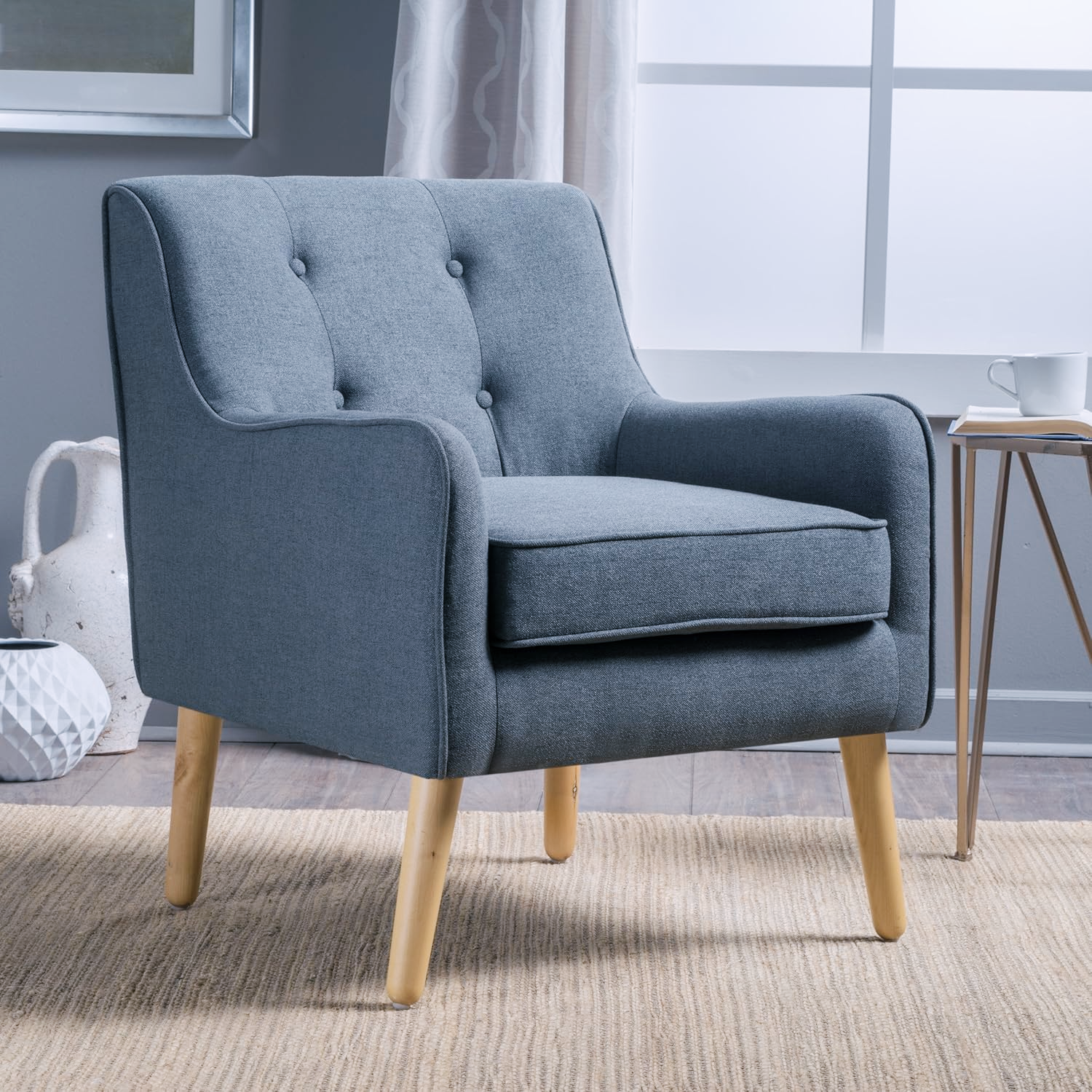 A blue upholstered armchair with wooden legs in a therapy private practice room.
