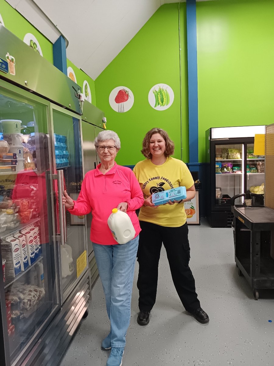 two volunteers stock foodshare fridge