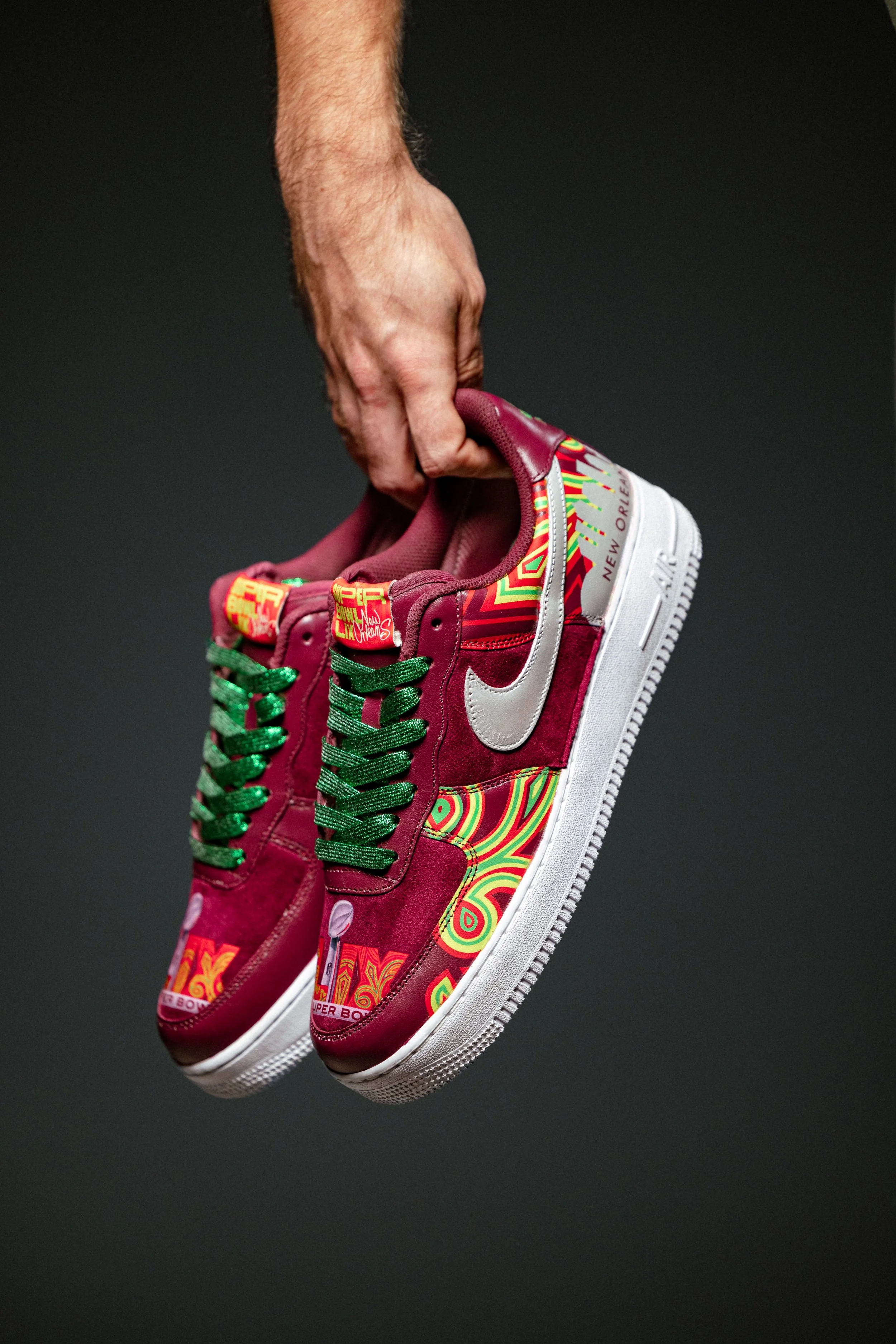 Hand holding pair of custom superbowl sneakers
