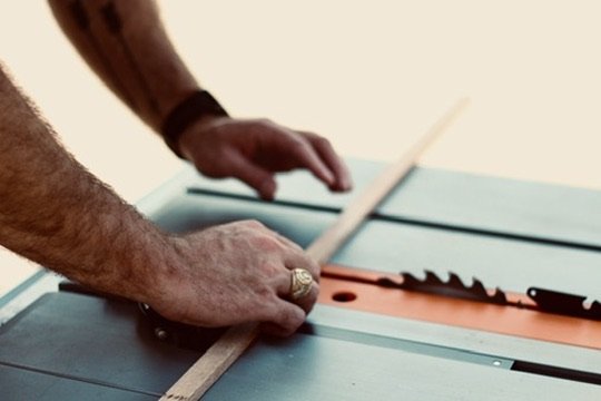 Founders hands working with wood on a table saw