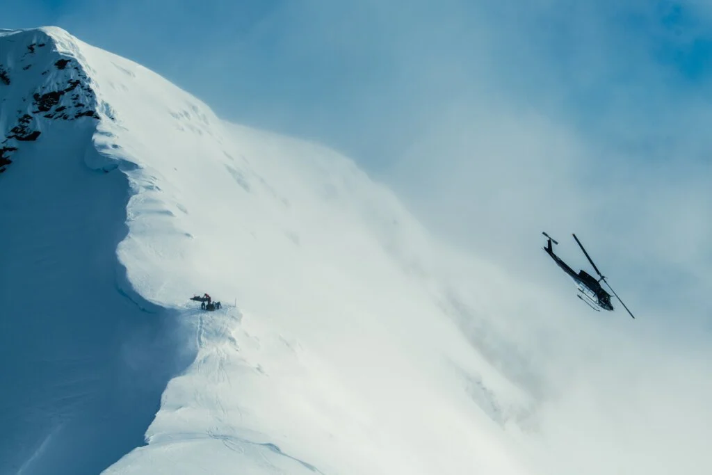 Helicopter departing after dropping skiers on a remote ridge at Silvertip.