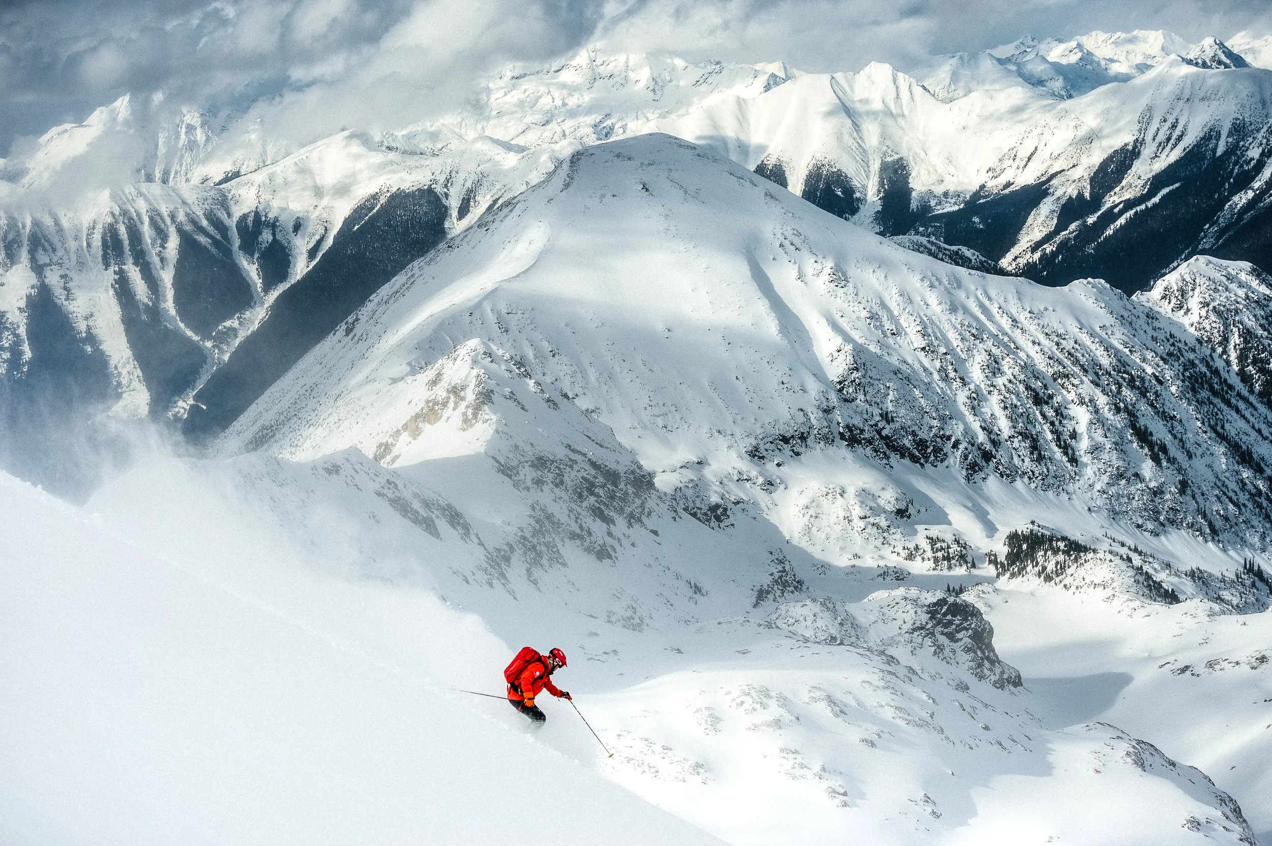 Skier traversing open alpine terrain on a clear bluebird day at Silvertip.
