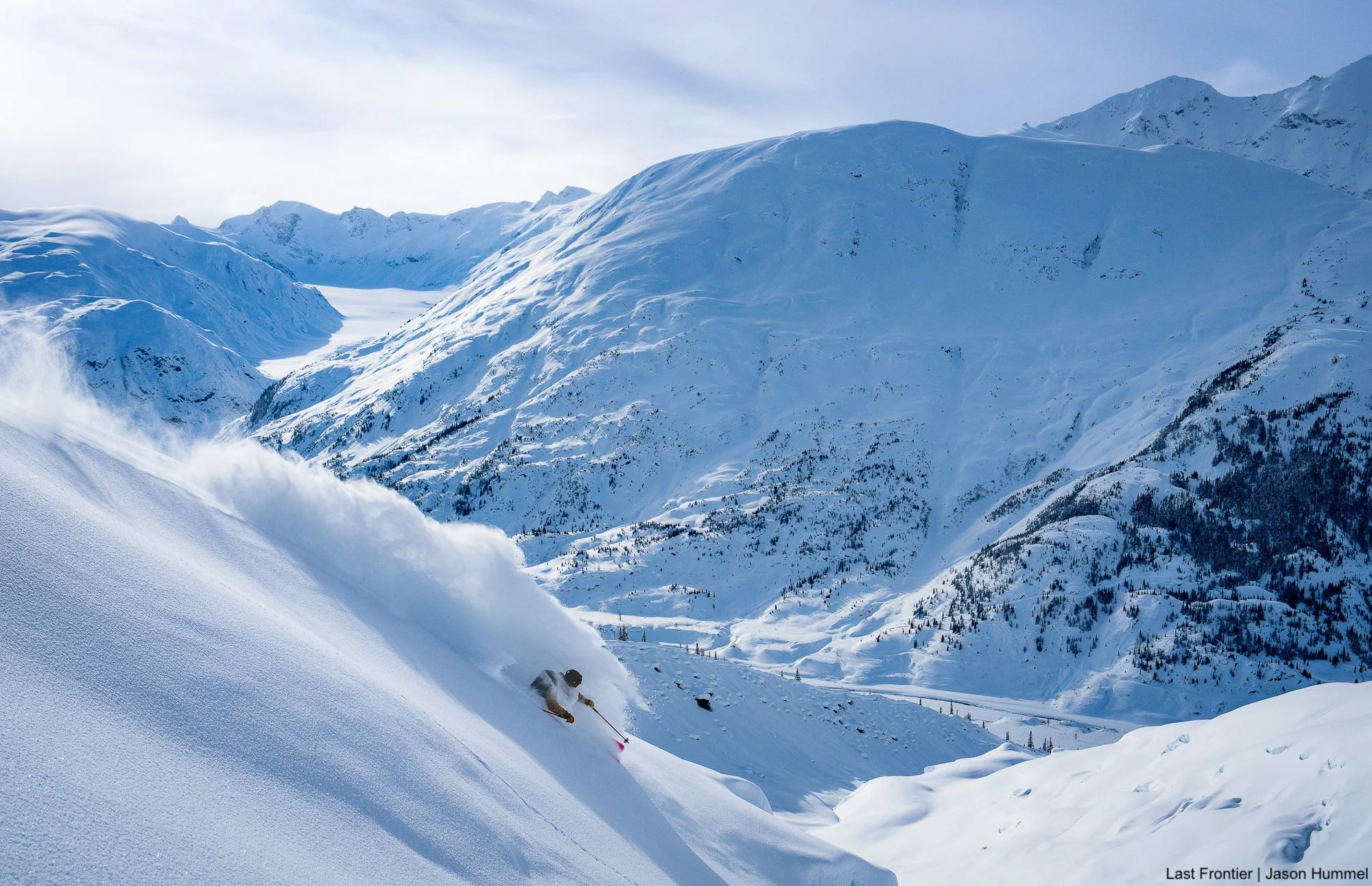 Skier making a deep powder turn above the Coast Mountains near Ripley Creek.