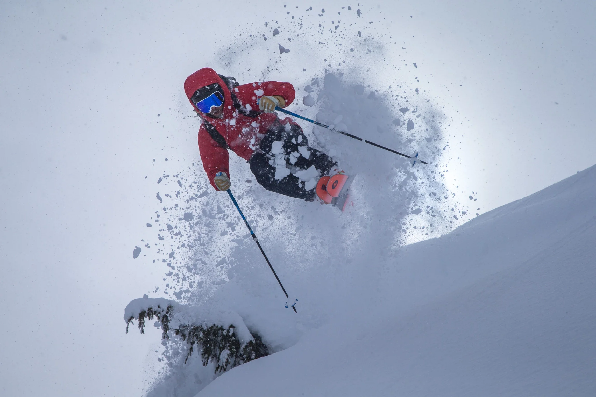 Skier popping off a snow-covered pillow in deep powder